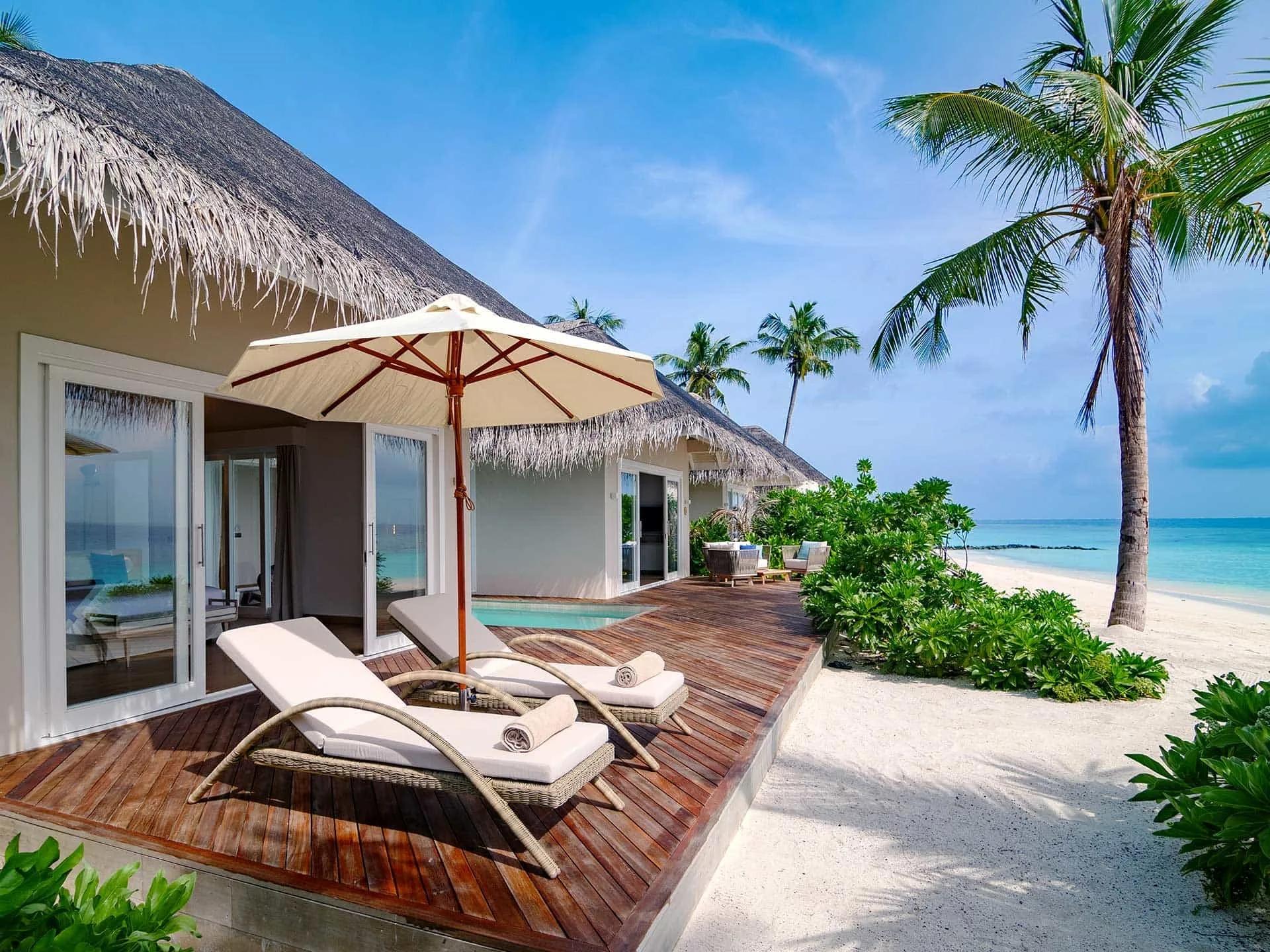 A Deluxe Beach Suite with Pool's shaded terrace, private pool and sun loungers, steps from the beach at Baglioni Maldives
