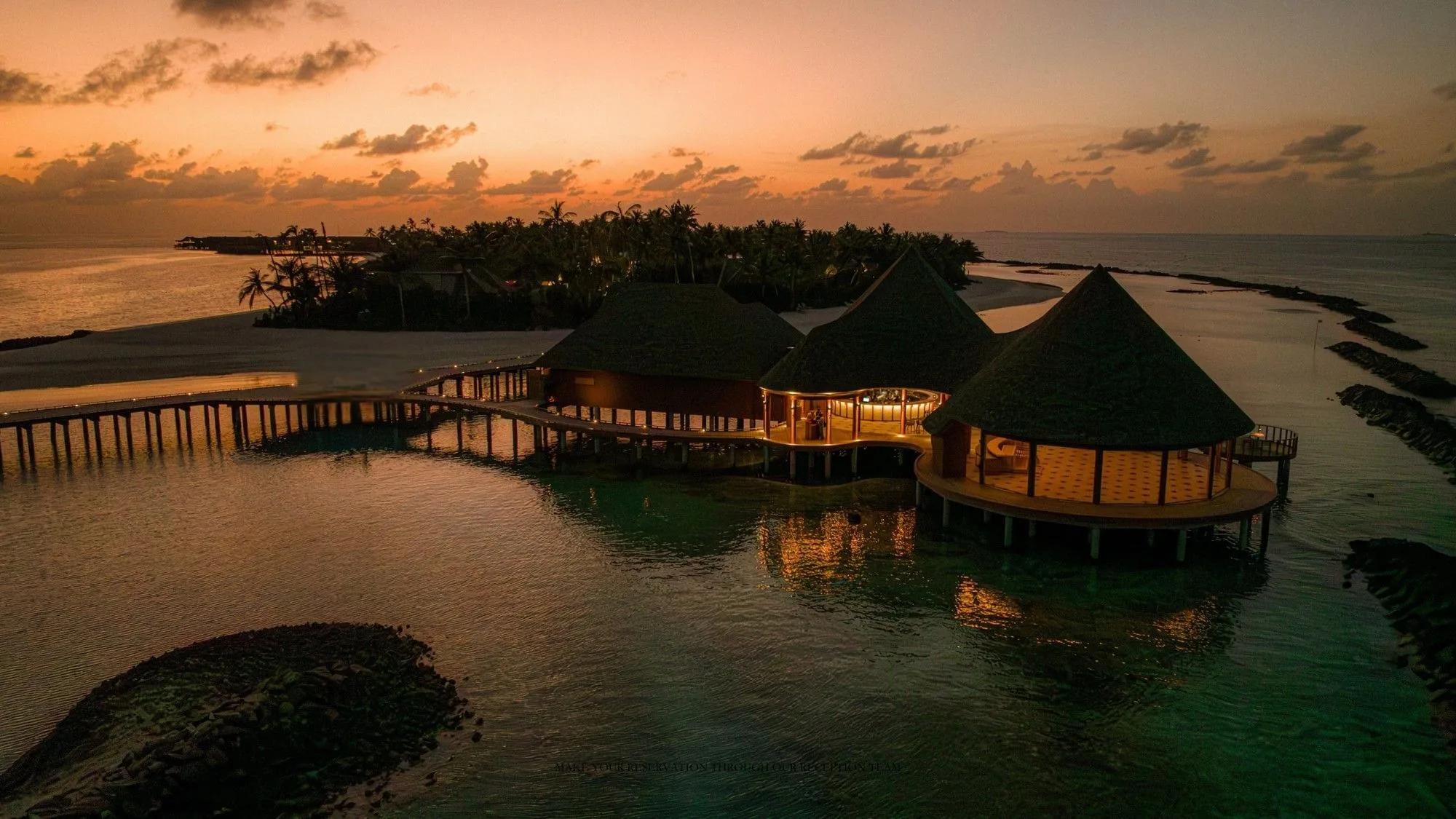 Luna's overwater dining hall at dusk, ananea Madivaru's signature restaurant strung between its two islands