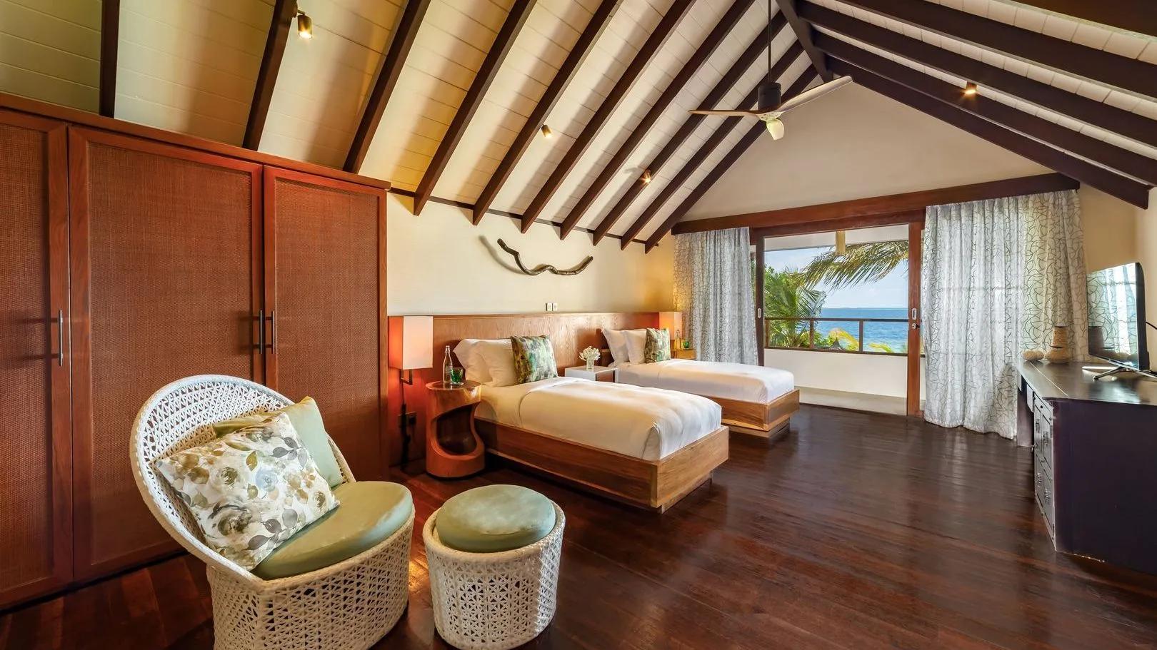 The twin-bed second bedroom of an Earth Pool RESERVE Sunset villa, with a private balcony over the ocean