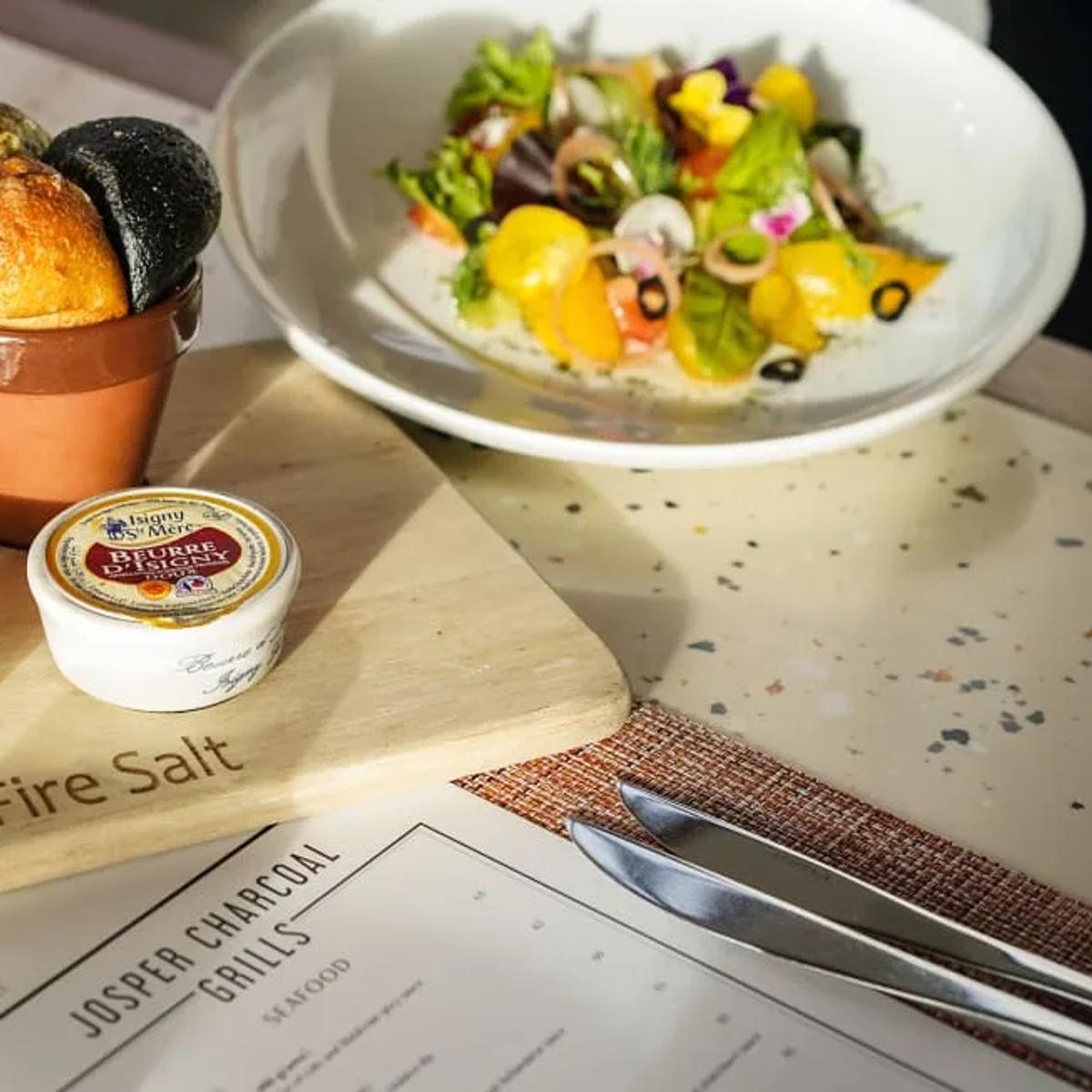 Bread, butter and a salad plate set on the Sea Fire Salt branded board
