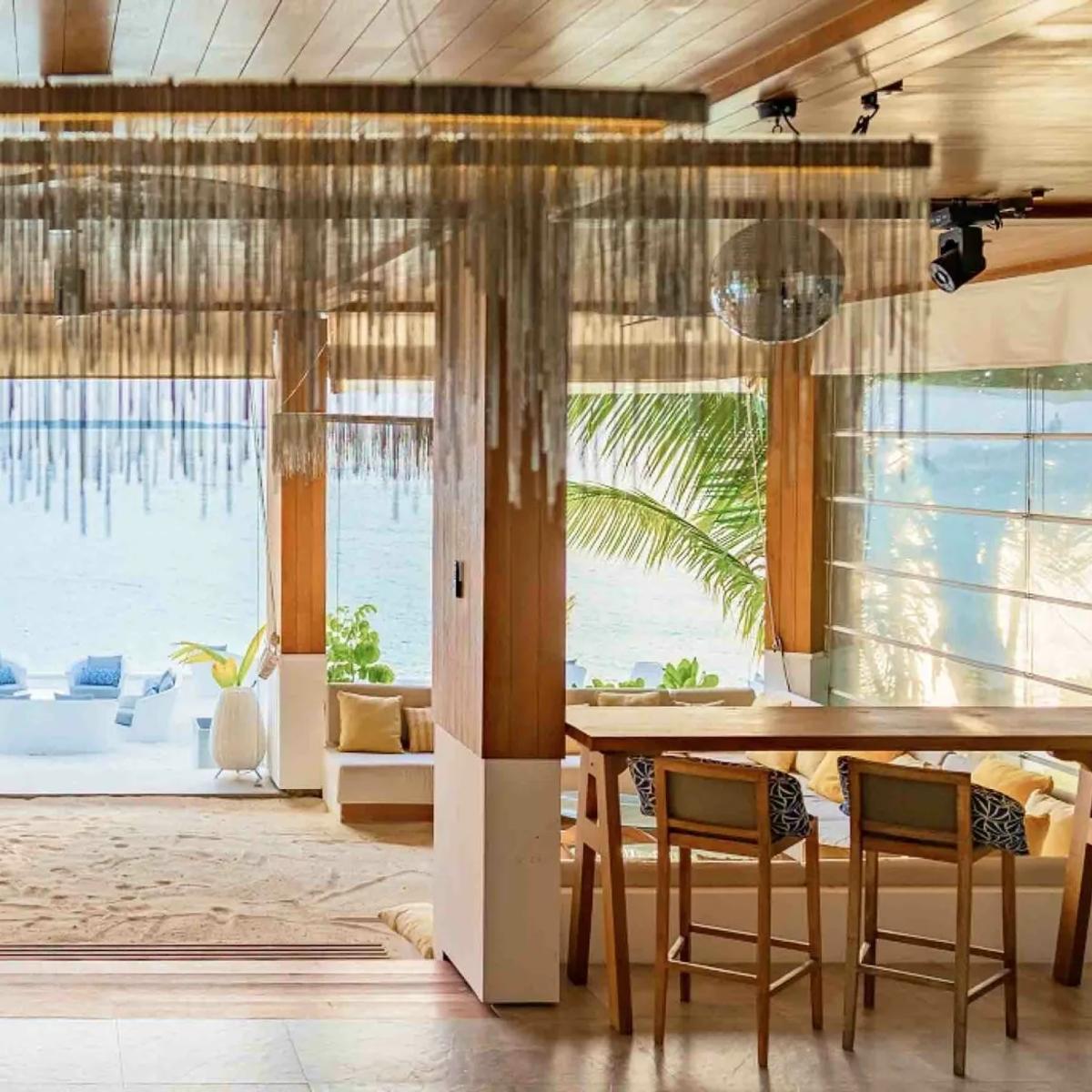 Baa Bar's lounge interior at Amilla, fringe curtains and a mirror ball over the ocean-facing bar