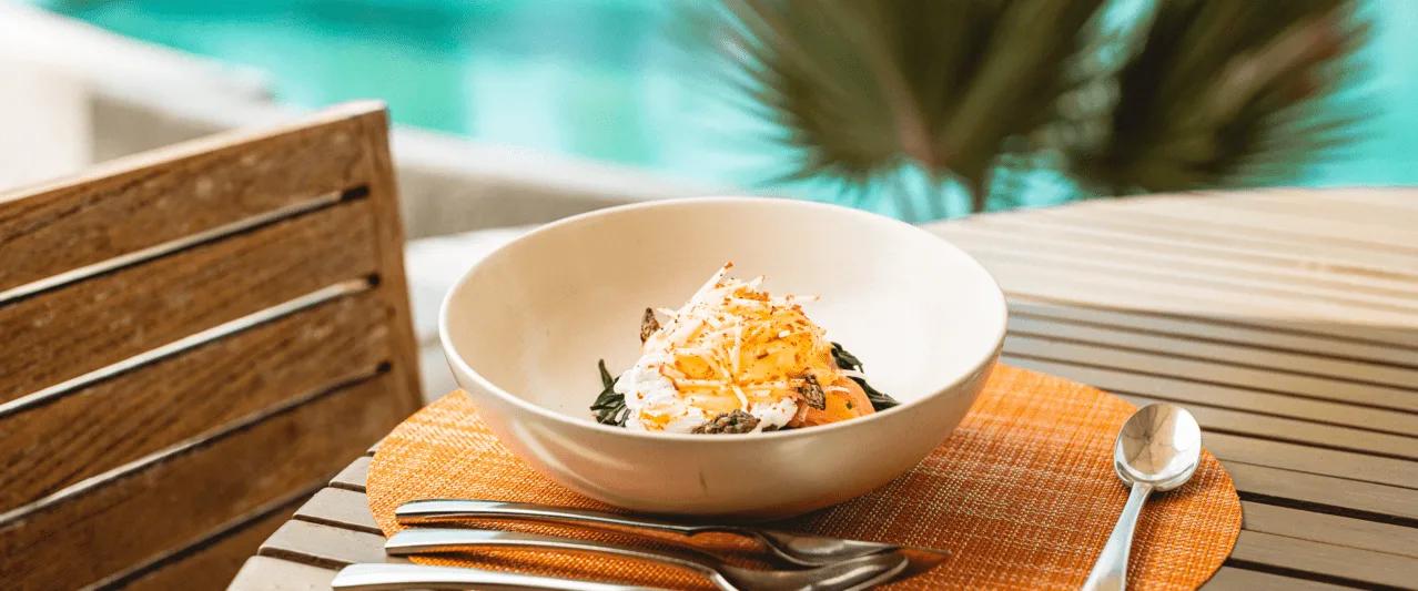 A plated dish set beside the pool at Mixe