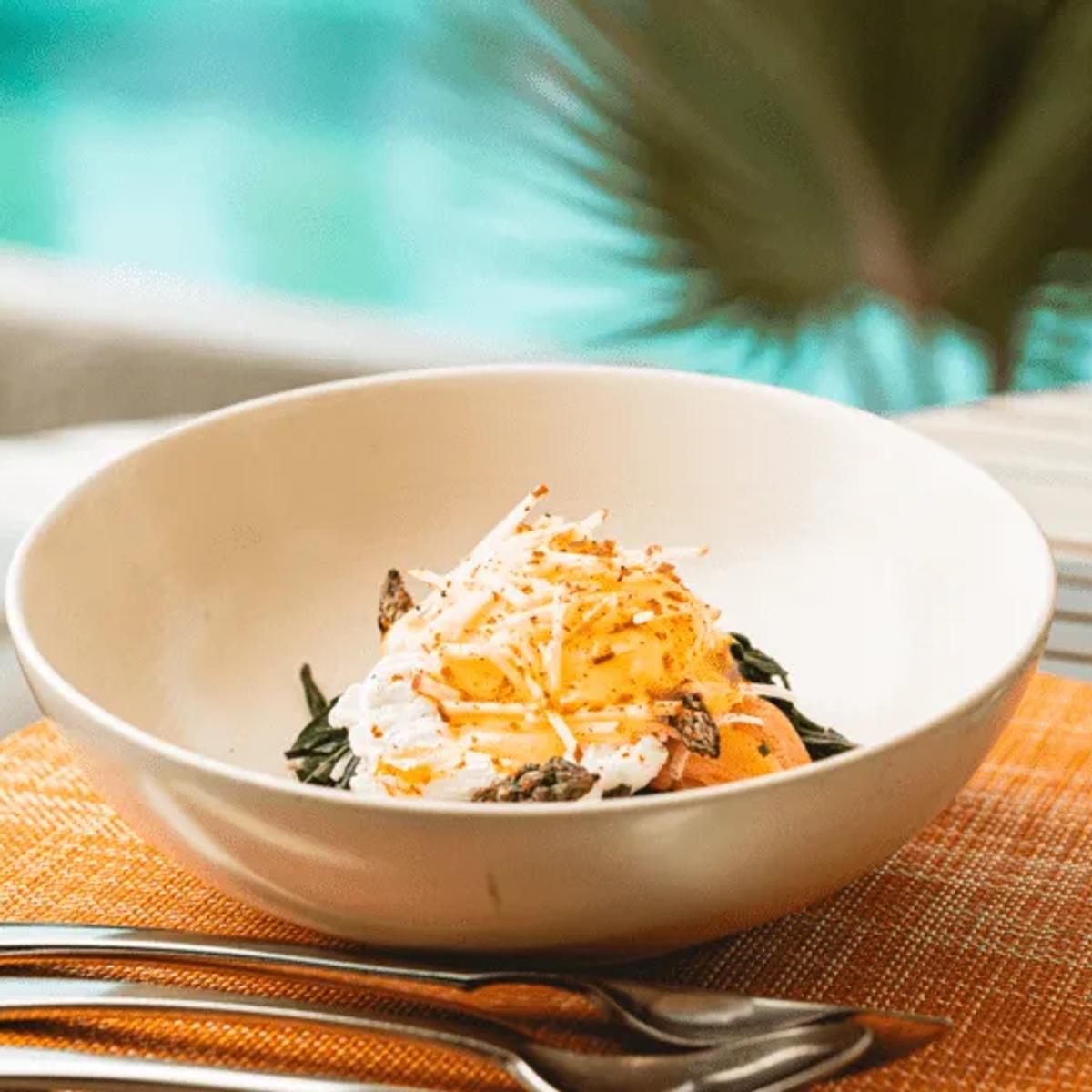 A plated dish set beside the pool at Mixe