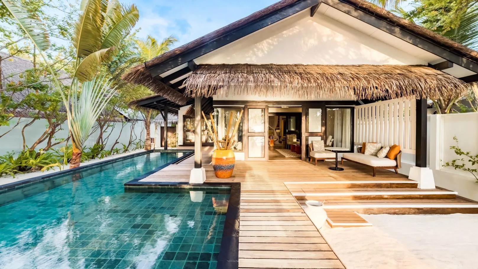The two-bedroom Earth Pool Pavilion's private pool and covered deck, palm trees overhead