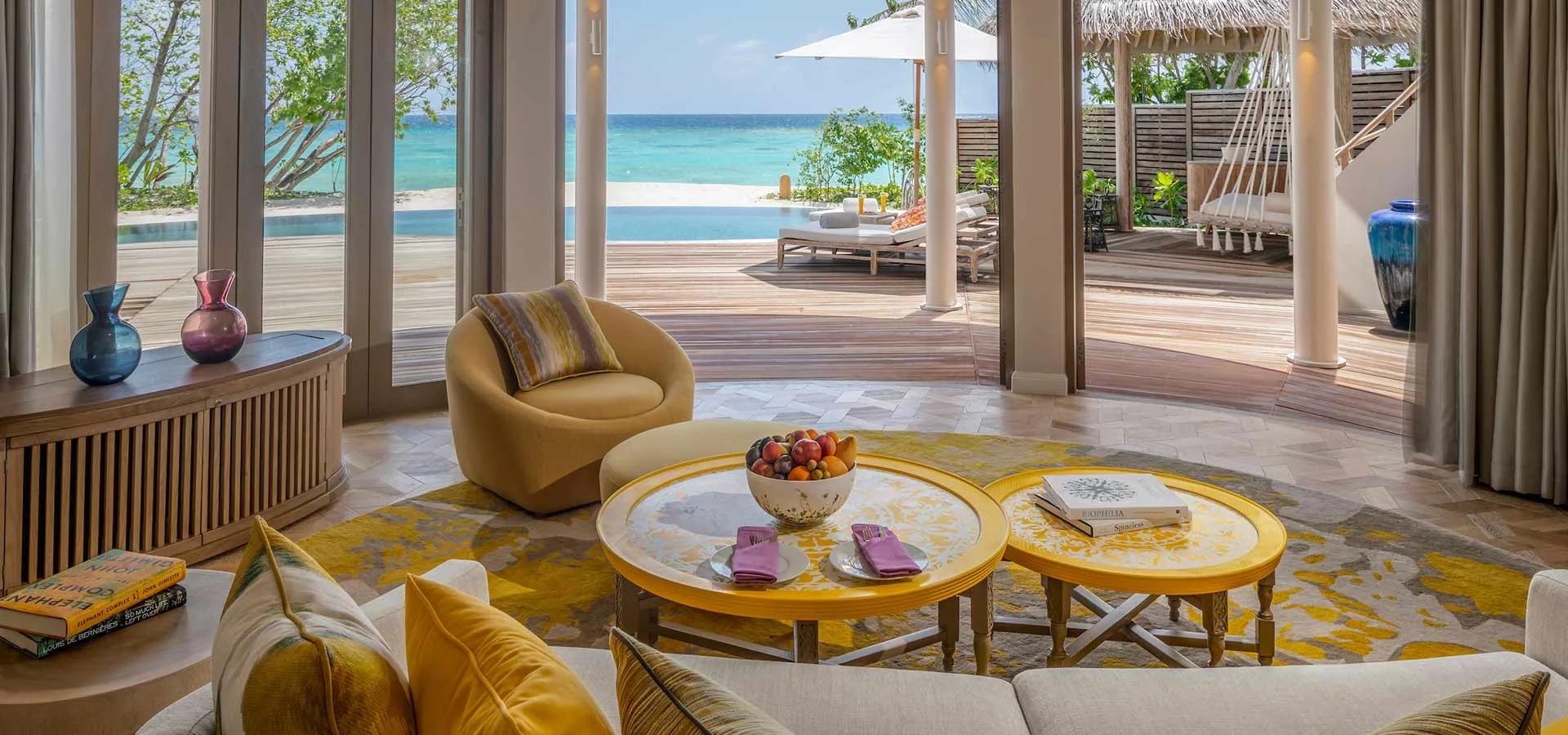 A Two-Bedroom Beach Residence living room, with a hanging swing seat and pool deck visible through the doors.