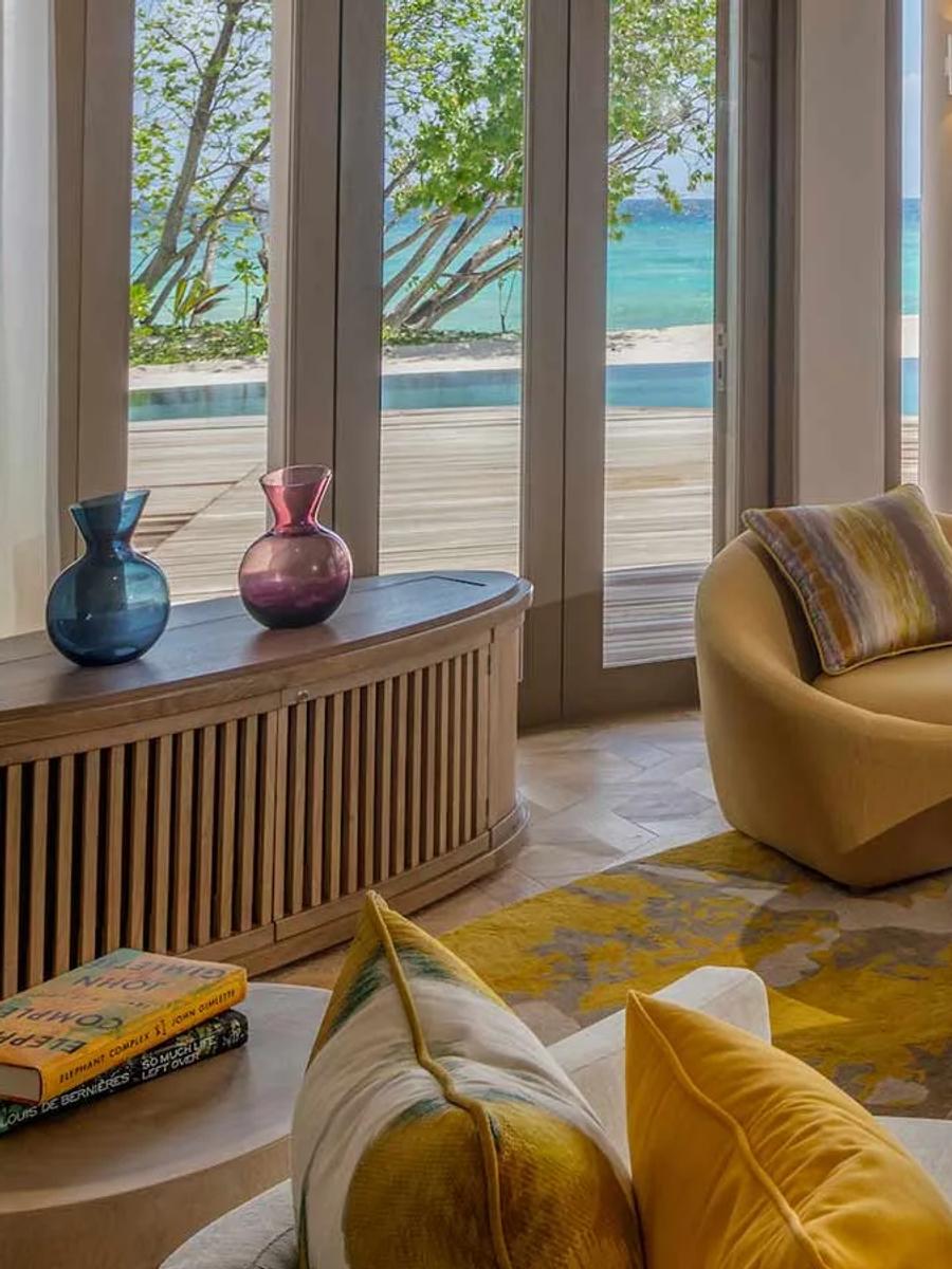 A Two-Bedroom Beach Residence living room, with a hanging swing seat and pool deck visible through the doors.