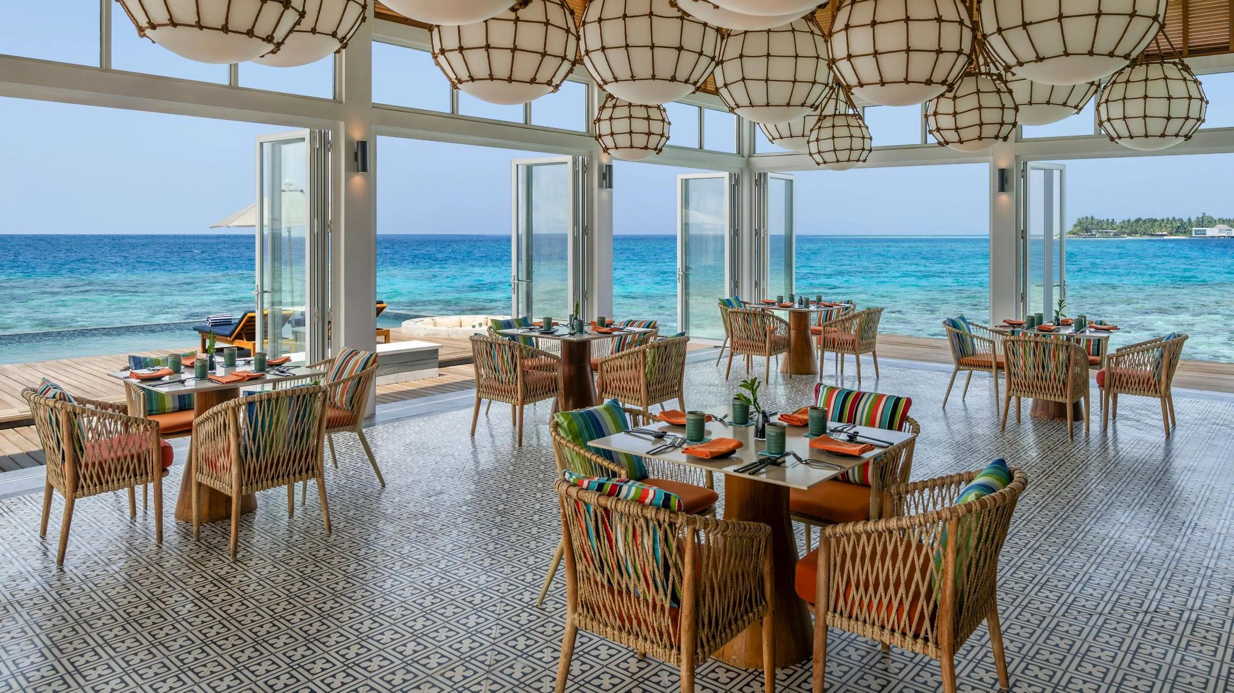 Yuzu's overwater dining room, panoramic ocean views through floor-to-ceiling glass