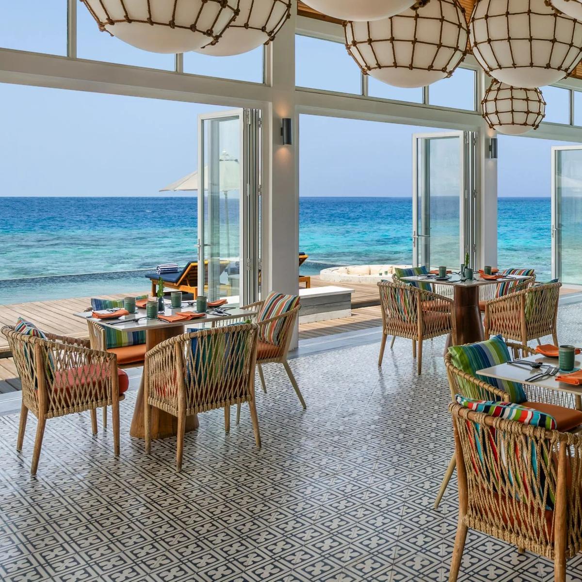 Yuzu's overwater dining room, panoramic ocean views through floor-to-ceiling glass