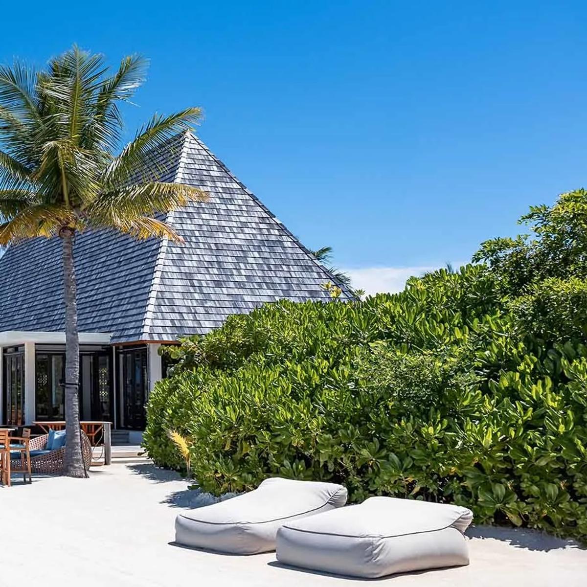 Mar-Umi's beachfront terrace at Kuda Villingili Resort Maldives, tables set beneath palms by the lagoon