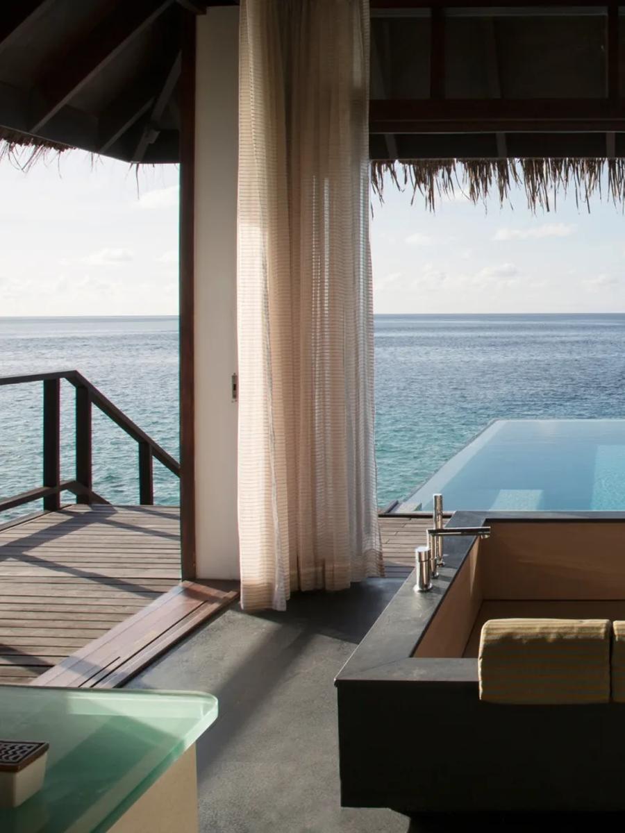 Private overwater plunge pool of an Escape Water Villa with Pool, deck furniture and open lagoon beyond