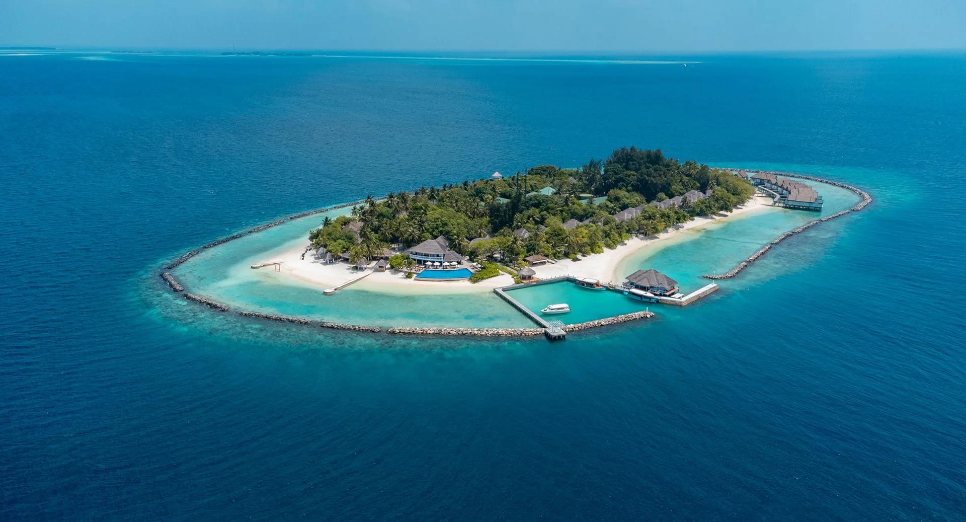 The island seen from above, its jetty and dive centre reaching into the lagoon on the near shore