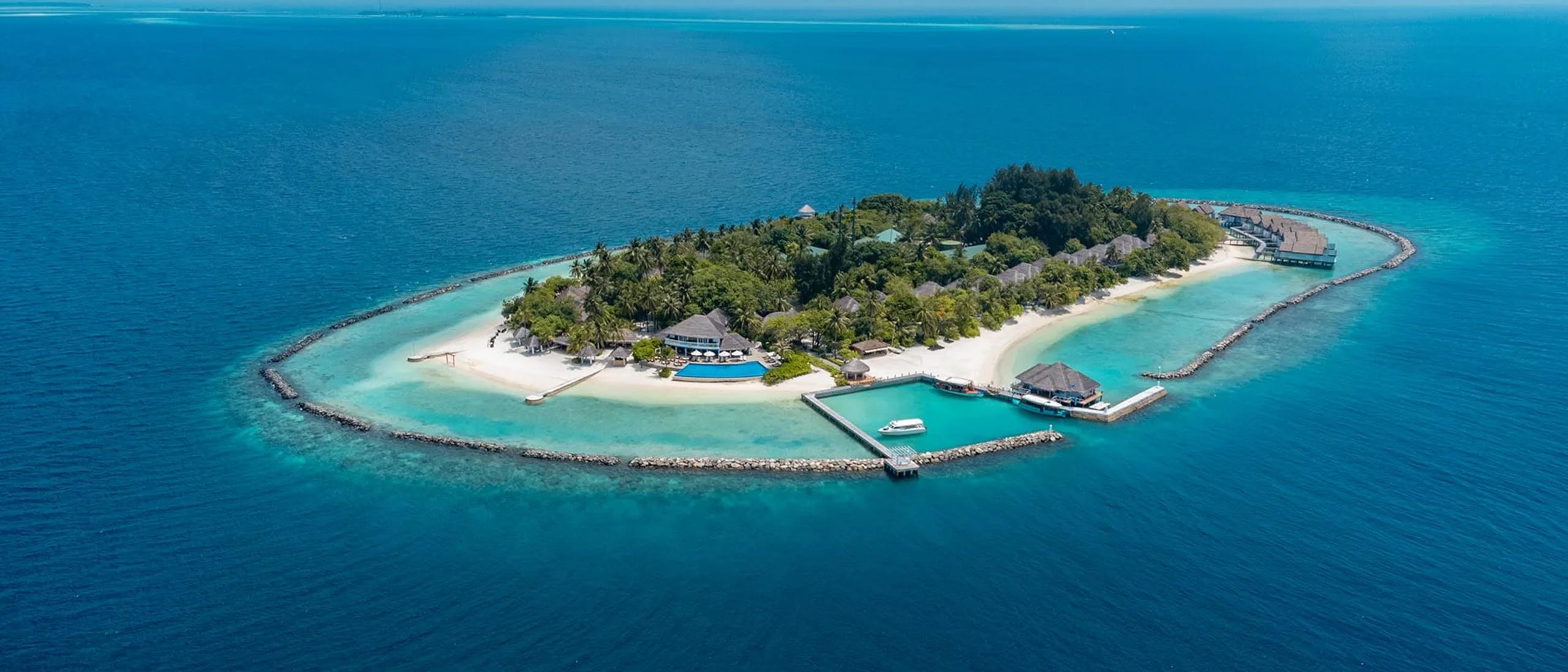 The island seen from above, its jetty and dive centre reaching into the lagoon on the near shore