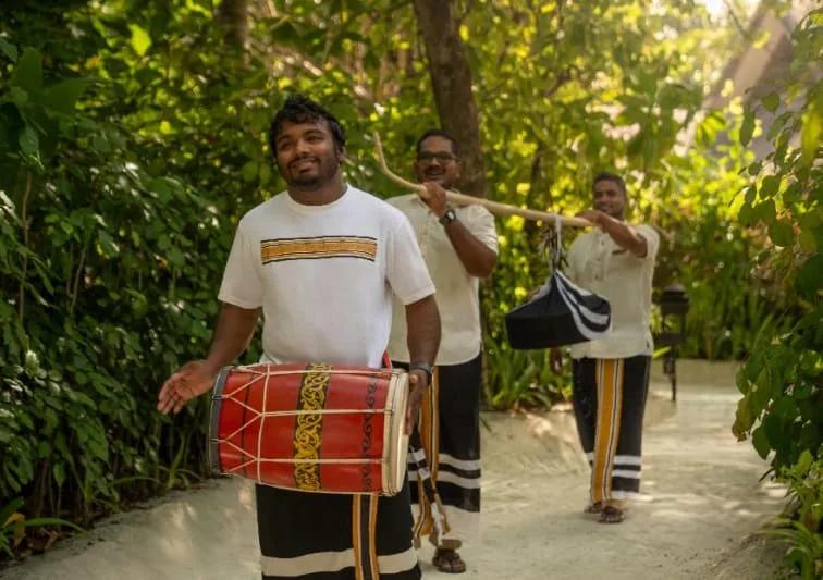 Traditional Maldivian drummers walking a garden path at the resort