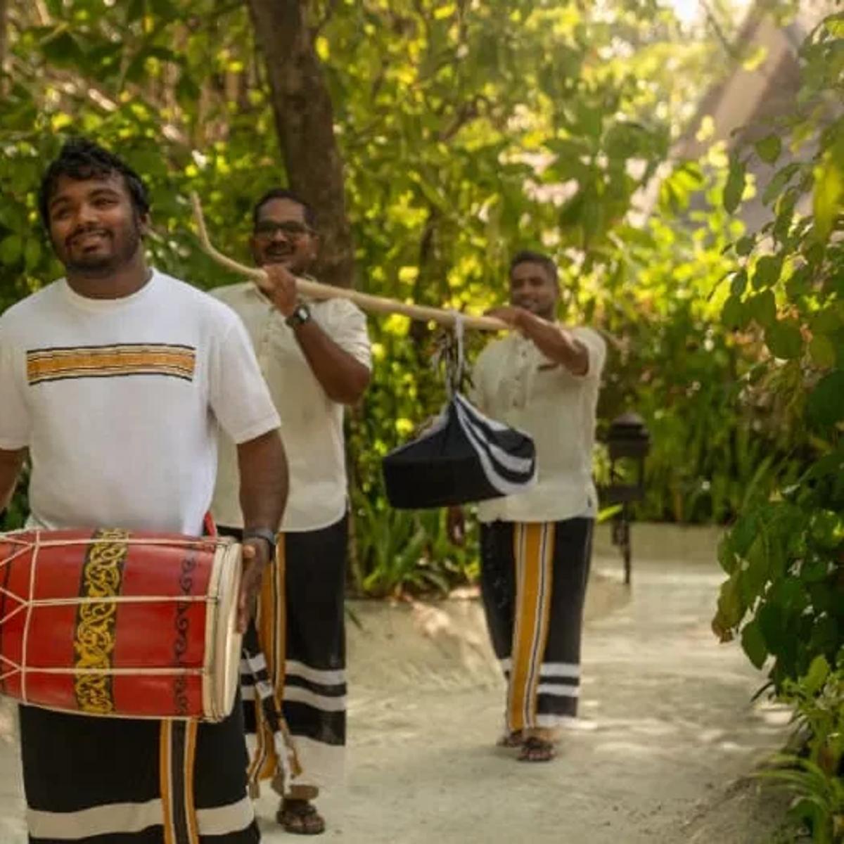 Traditional Maldivian drummers walking a garden path at the resort