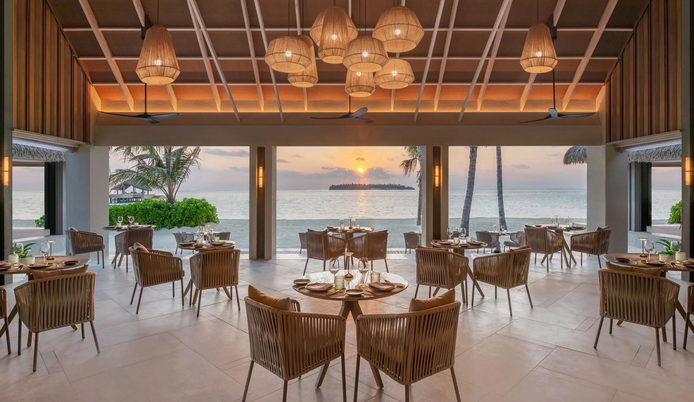 Riva's oceanfront dining room glowing at sunset