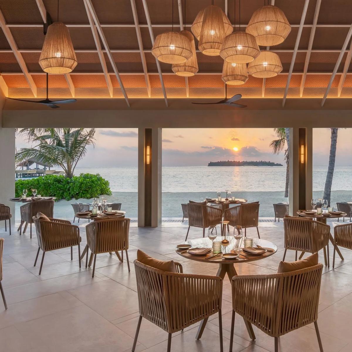 Riva's oceanfront dining room glowing at sunset