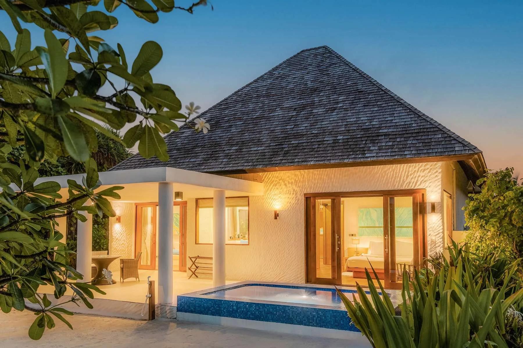 A Beach Residence with Plunge Pool lit at dusk, its private pool and bedroom open to the deck, Hideaway Beach Resort & Spa