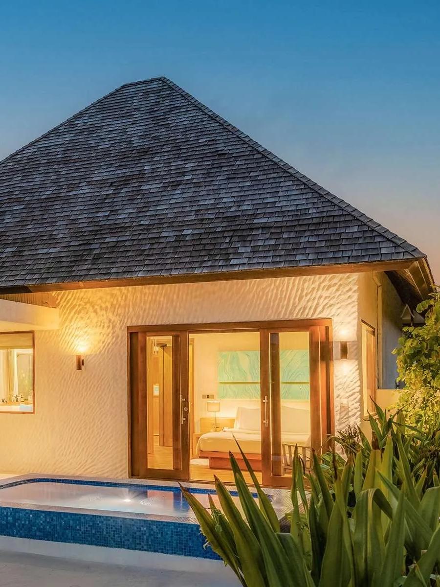 A Beach Residence with Plunge Pool lit at dusk, its private pool and bedroom open to the deck, Hideaway Beach Resort & Spa