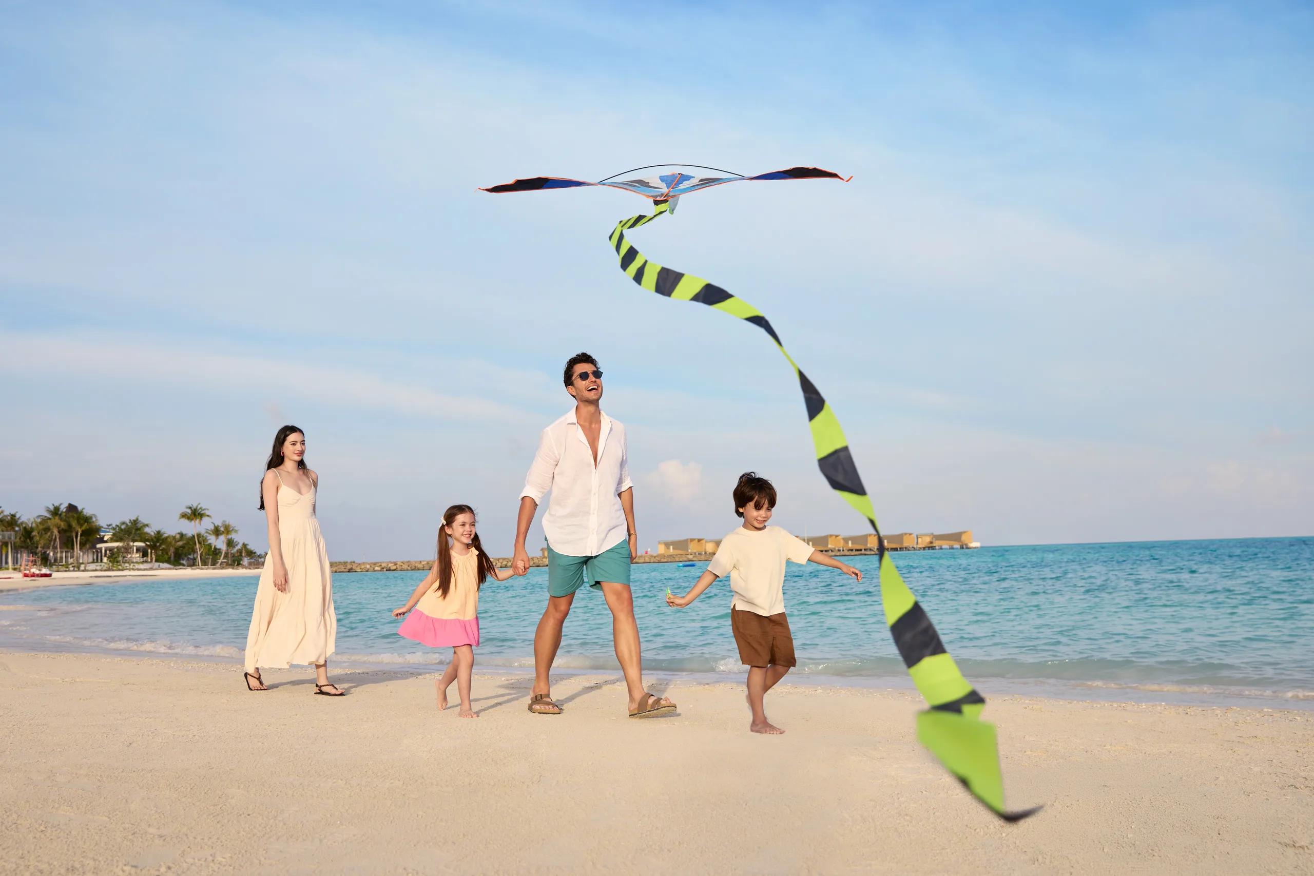 A family on the beach at Centara Mirage Lagoon Maldives (no dedicated Four Bedroom Beach House photo was available in the research pool)