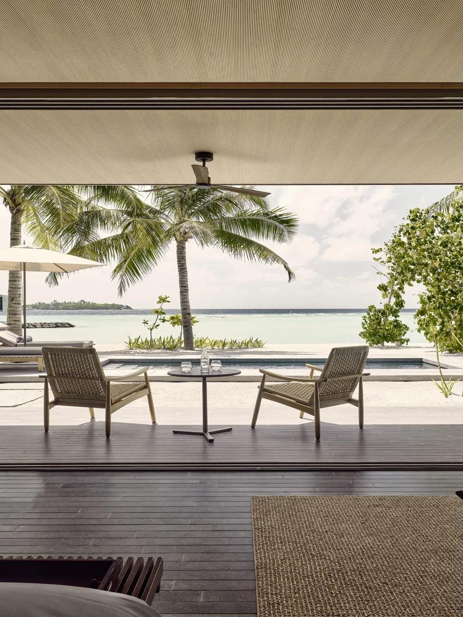 A private pool deck at a One-Bedroom Beach Pool Villa, an overwater villa visible across the lagoon
