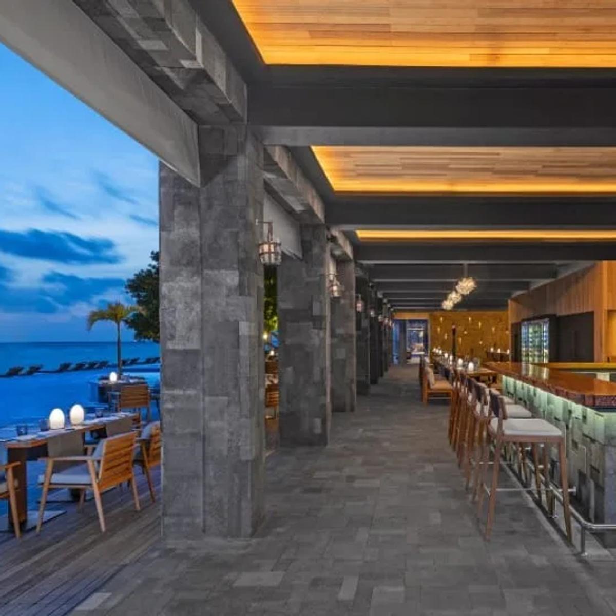 Poolside seating at MANZARU restaurant, Anantara Kihavah Maldives Villas