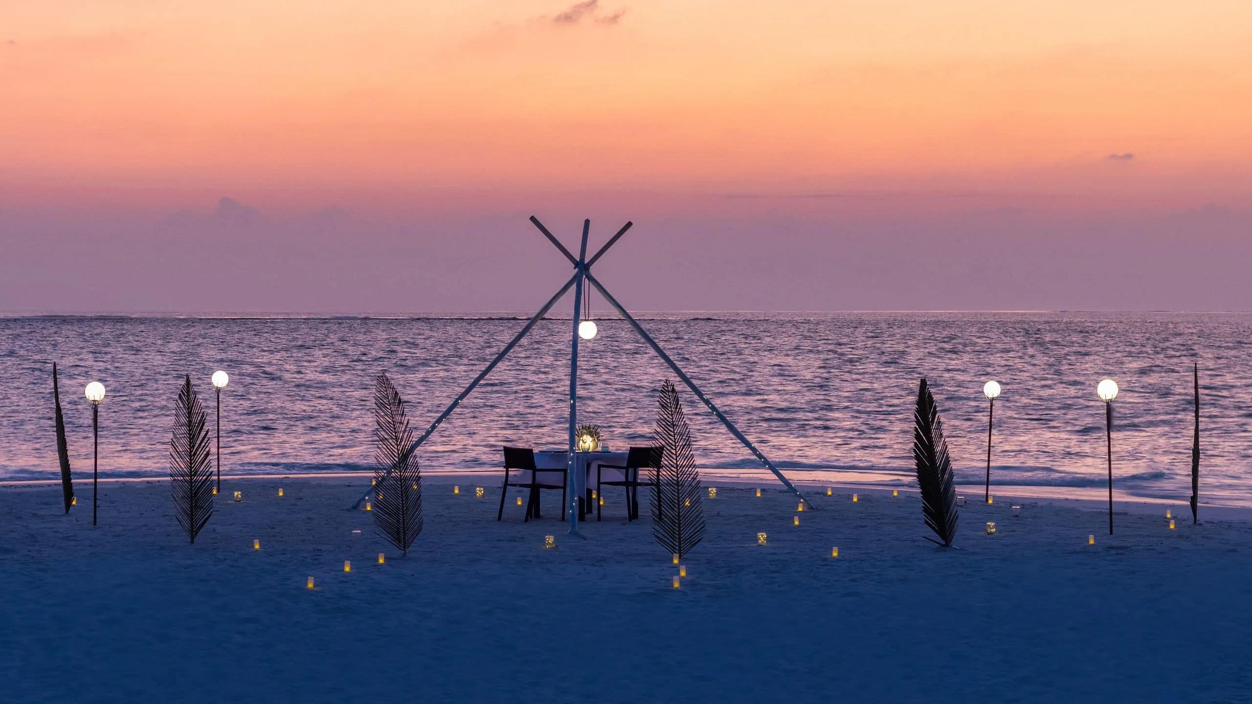 A romantic dinner set up on The Shack's private sandbank at sunset