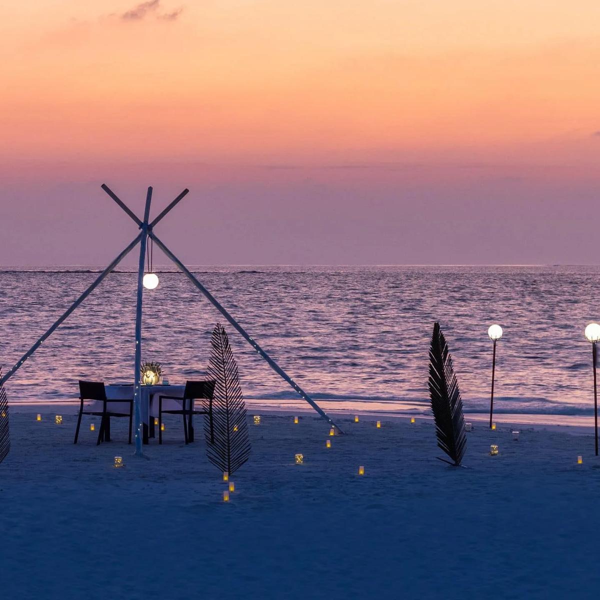 A romantic dinner set up on The Shack's private sandbank at sunset