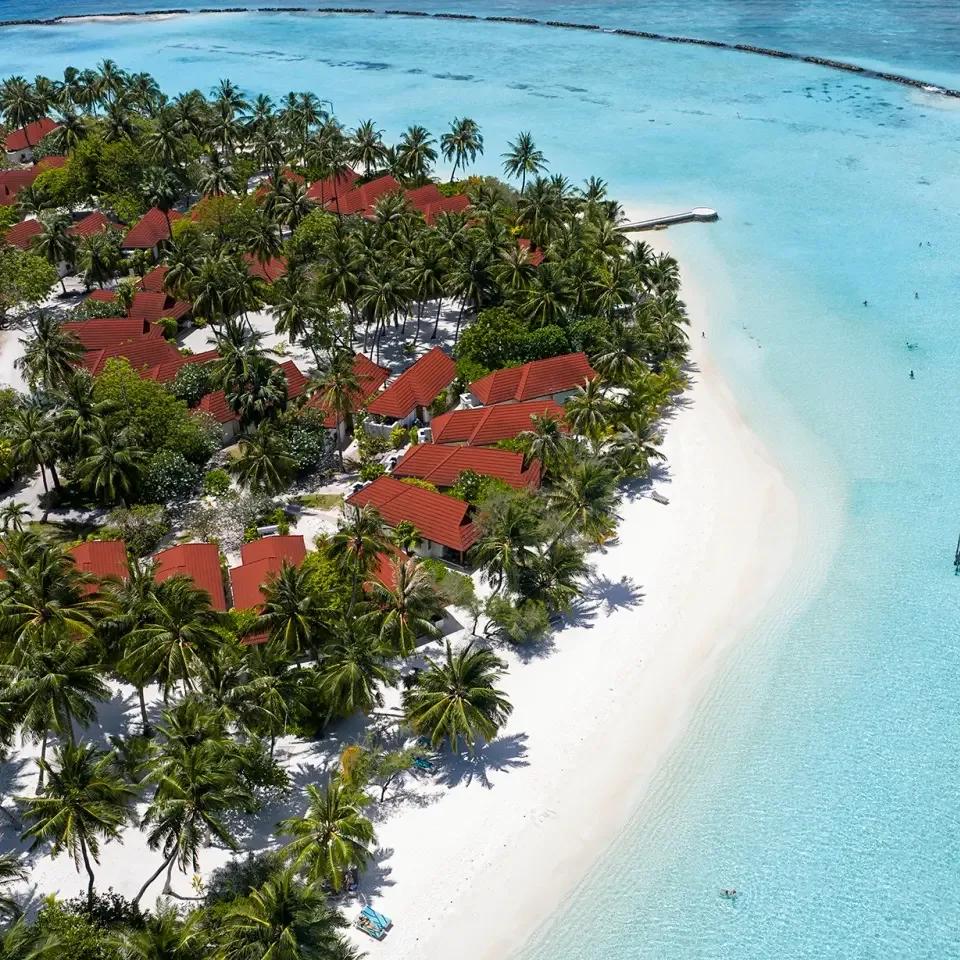 Aerial view of Niva Kurumba's bungalows lining the lagoon