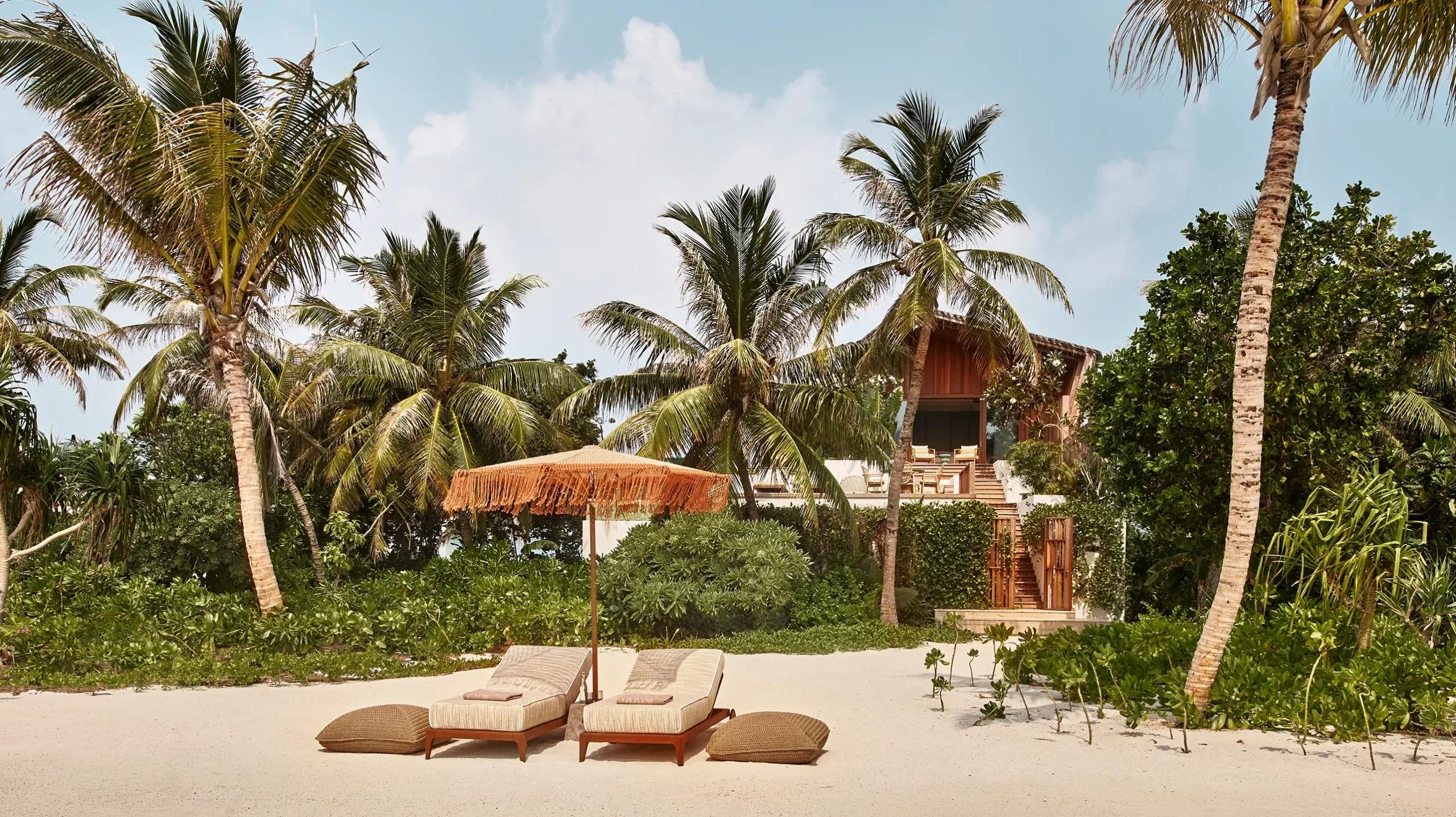 The beach approach to a 3-Bedroom Residence at .Here, sun loungers set among the palms
