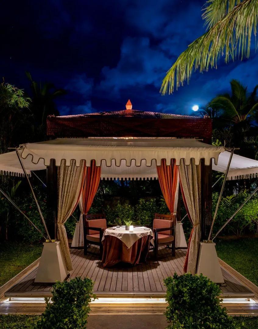 A private tented dining cabana at Saffron, set for two under lanterns at night