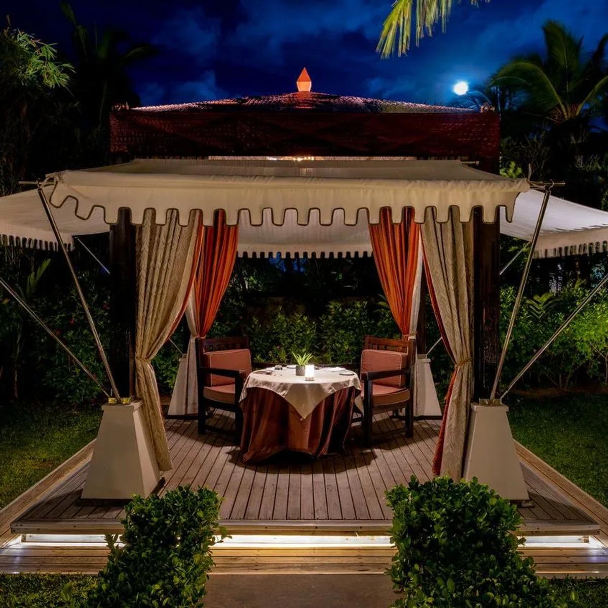 A private tented dining cabana at Saffron, set for two under lanterns at night