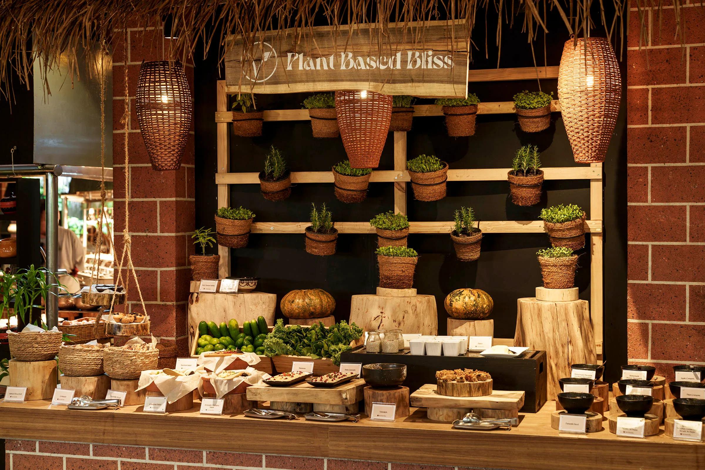 Curved brick buffet counters with pendant lighting and a thatched dessert station under a domed timber roof at Iru Restaurant