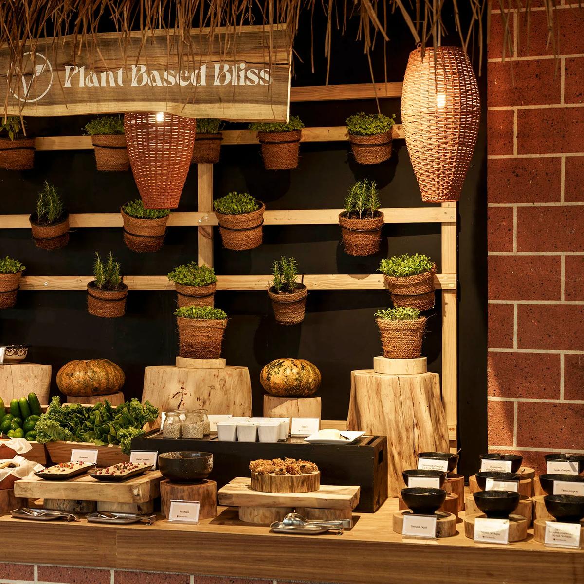 Curved brick buffet counters with pendant lighting and a thatched dessert station under a domed timber roof at Iru Restaurant