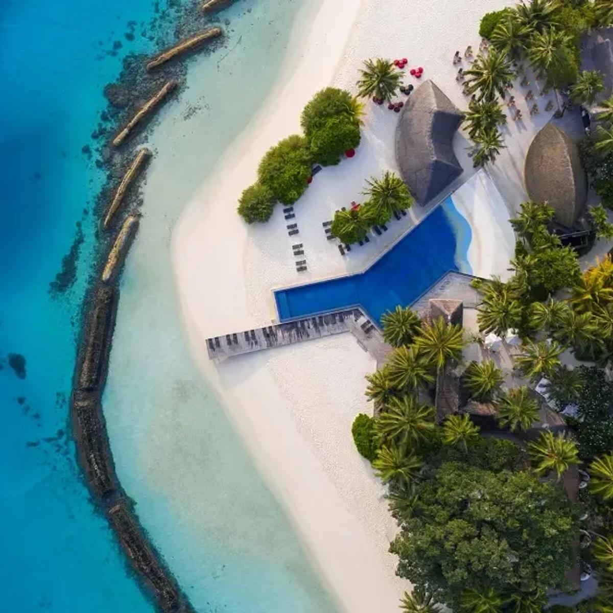 Aerial view of Kuramathi's main pool and beachfront pavilions near the island's dining quarter — no dedicated Island Coffee Shop photograph was available in the research set