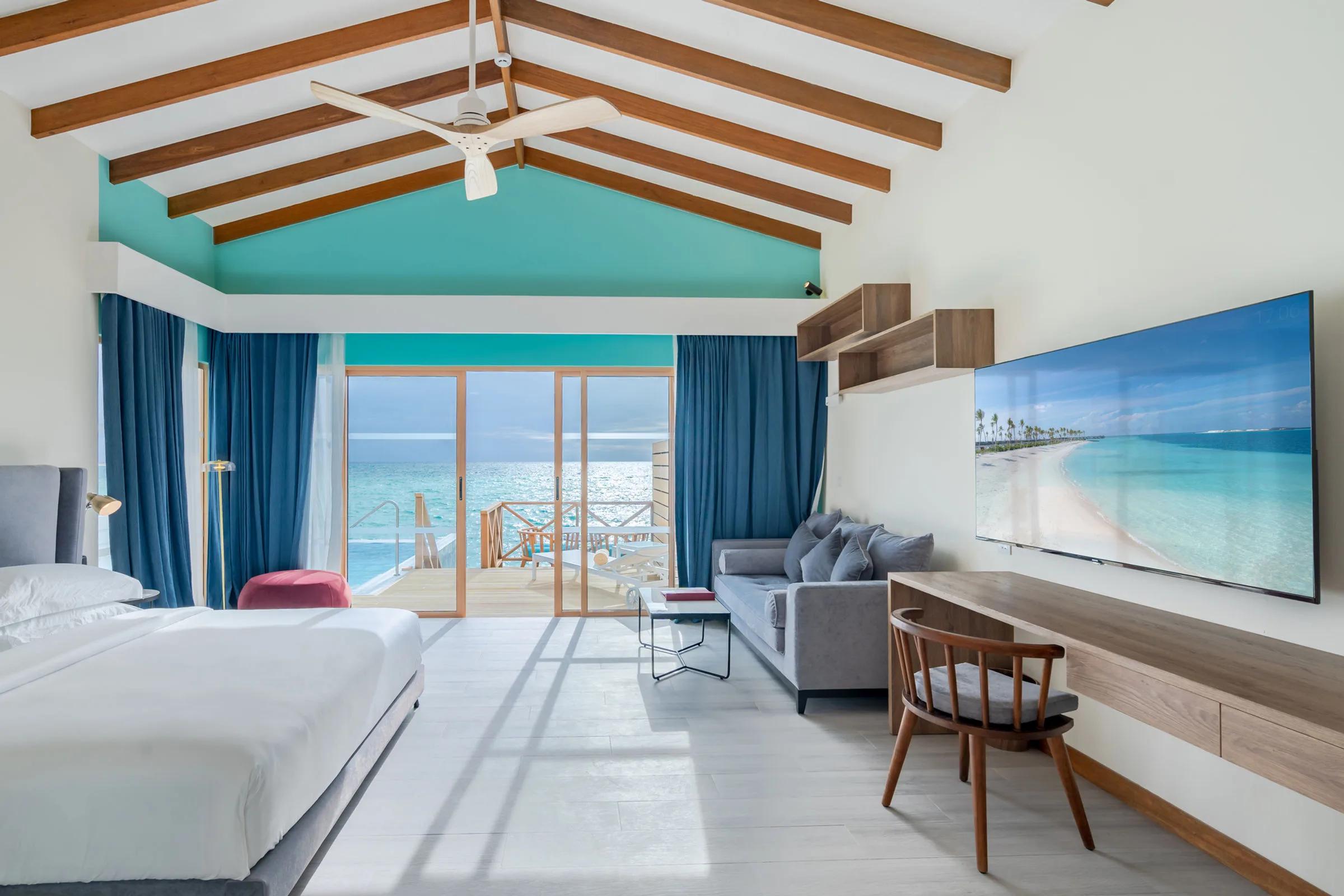 A Lagoon Suite Pool's bedroom, sliding doors open onto its wade-in pool and deck above the lagoon