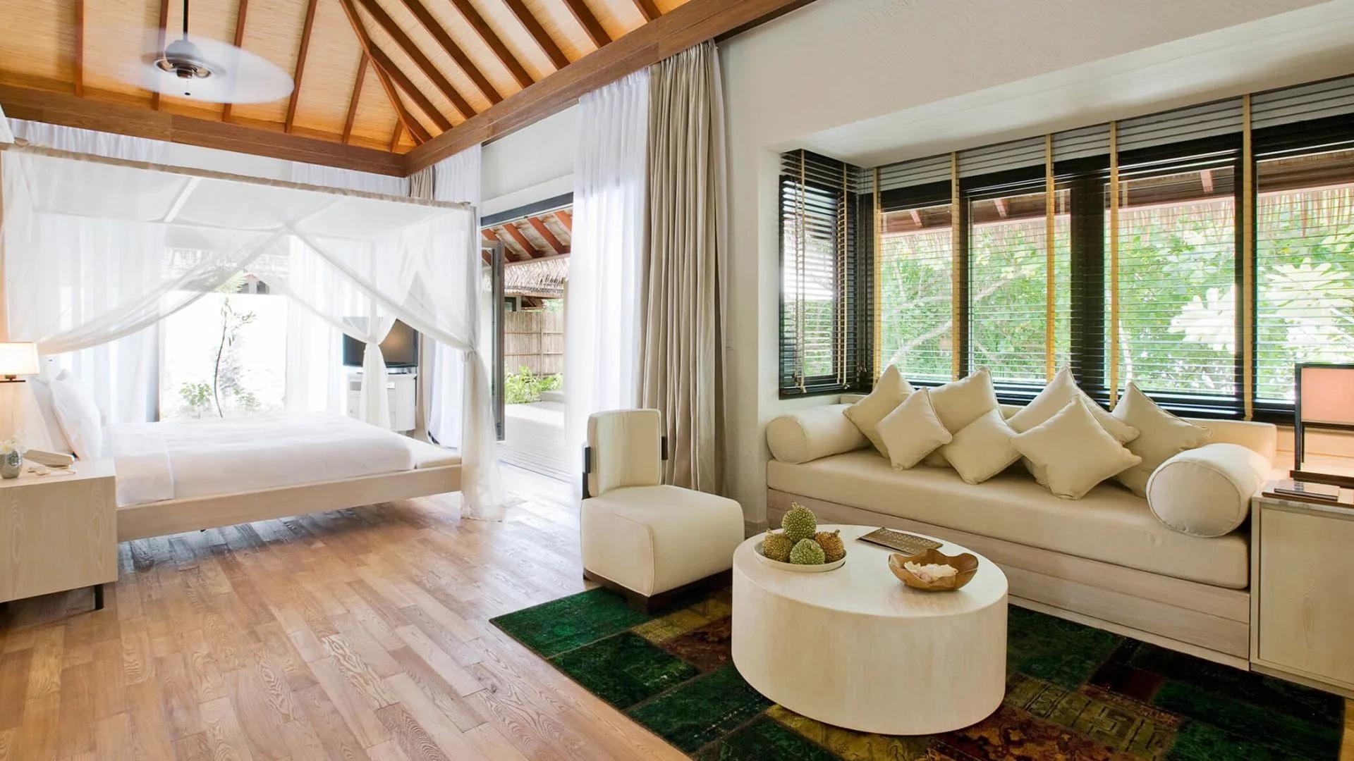 Two-Bedroom Beach Suite bedroom and lounge area, with a canopy bed and a daybed sofa by the window