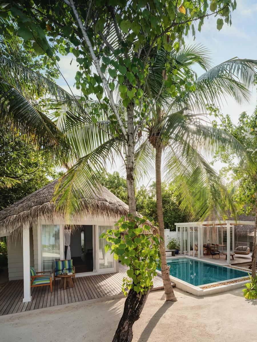 Aerial view of a Two Bedroom Beach Villa with Pool, its two-storey thatched roofline set beside a private pool and beachfront garden.