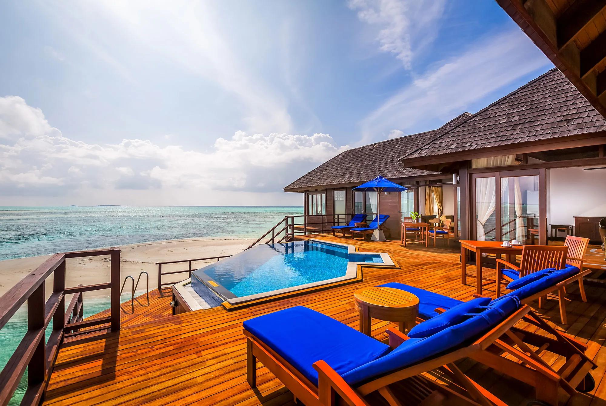 Living area of the Presidential Water Suite at Sun Siyam Olhuveli, opening onto an overwater deck