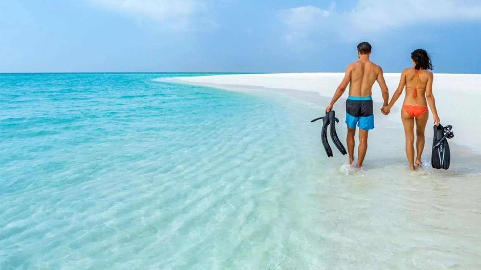 A couple snorkelling together over the shallow lagoon at Jawakara Islands Maldives