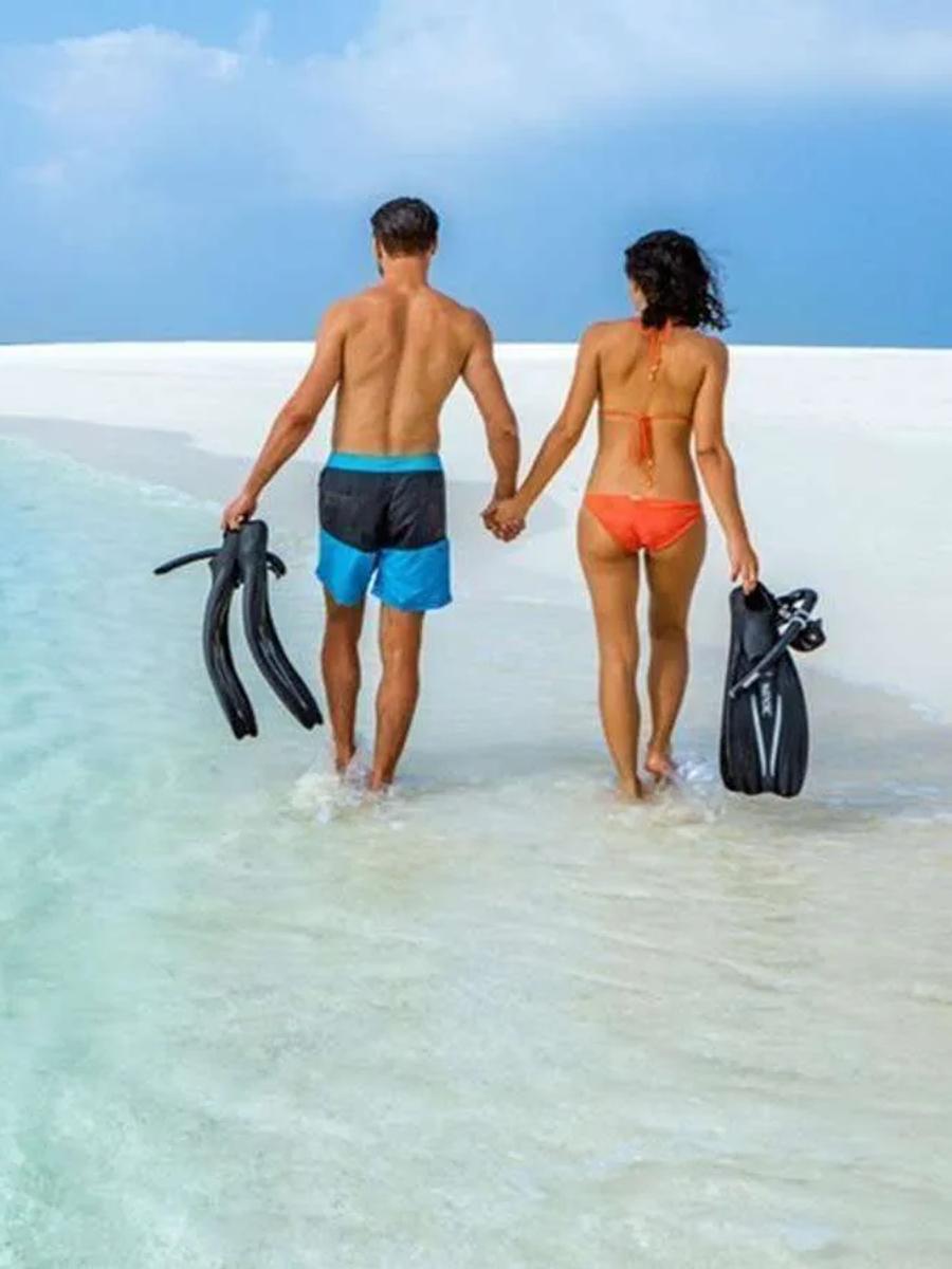 A couple snorkelling together over the shallow lagoon at Jawakara Islands Maldives