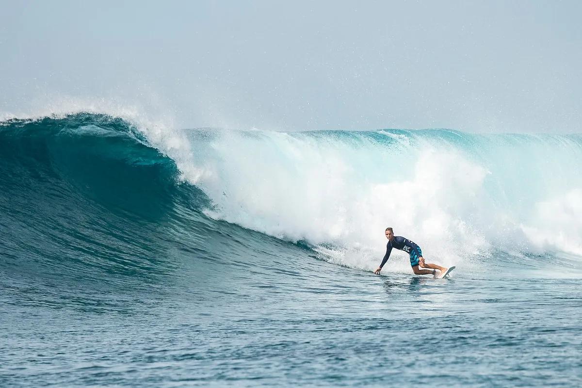 A surfer working with a Tropicsurf coach in the lagoon off Gili Lankanfushi
