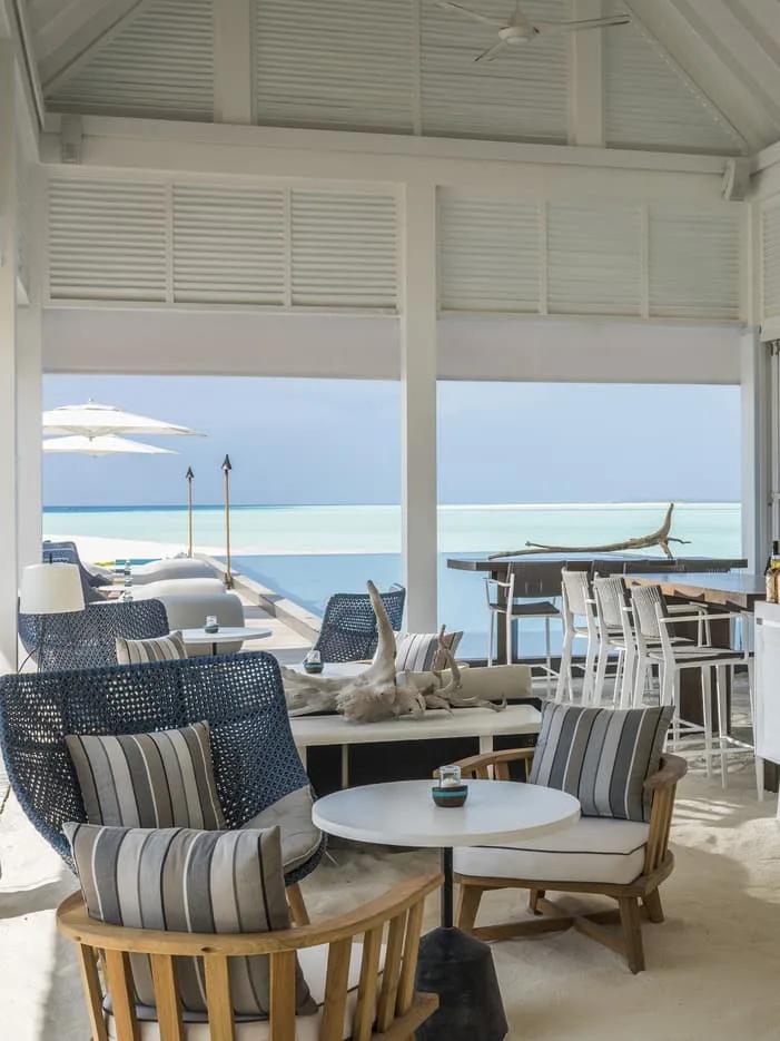 Blu Bar's open-air lounge with driftwood styling and bar stools overlooking the pool — standing in for Five Degrees North, which has no dedicated photograph in the source material