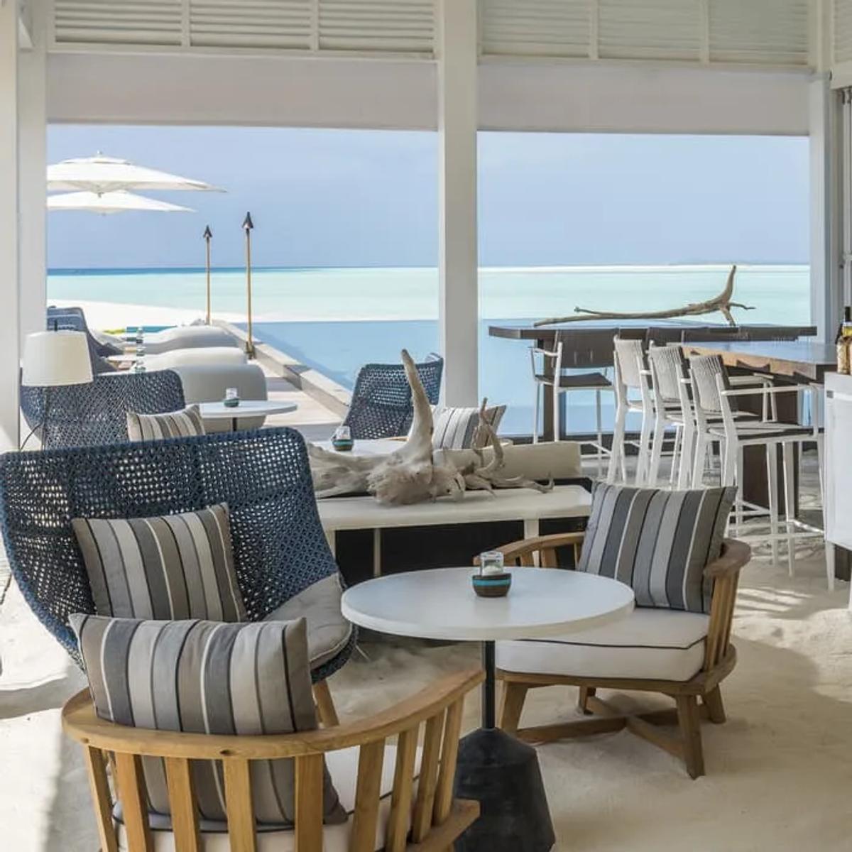 Blu Bar's open-air lounge with driftwood styling and bar stools overlooking the pool — standing in for Five Degrees North, which has no dedicated photograph in the source material