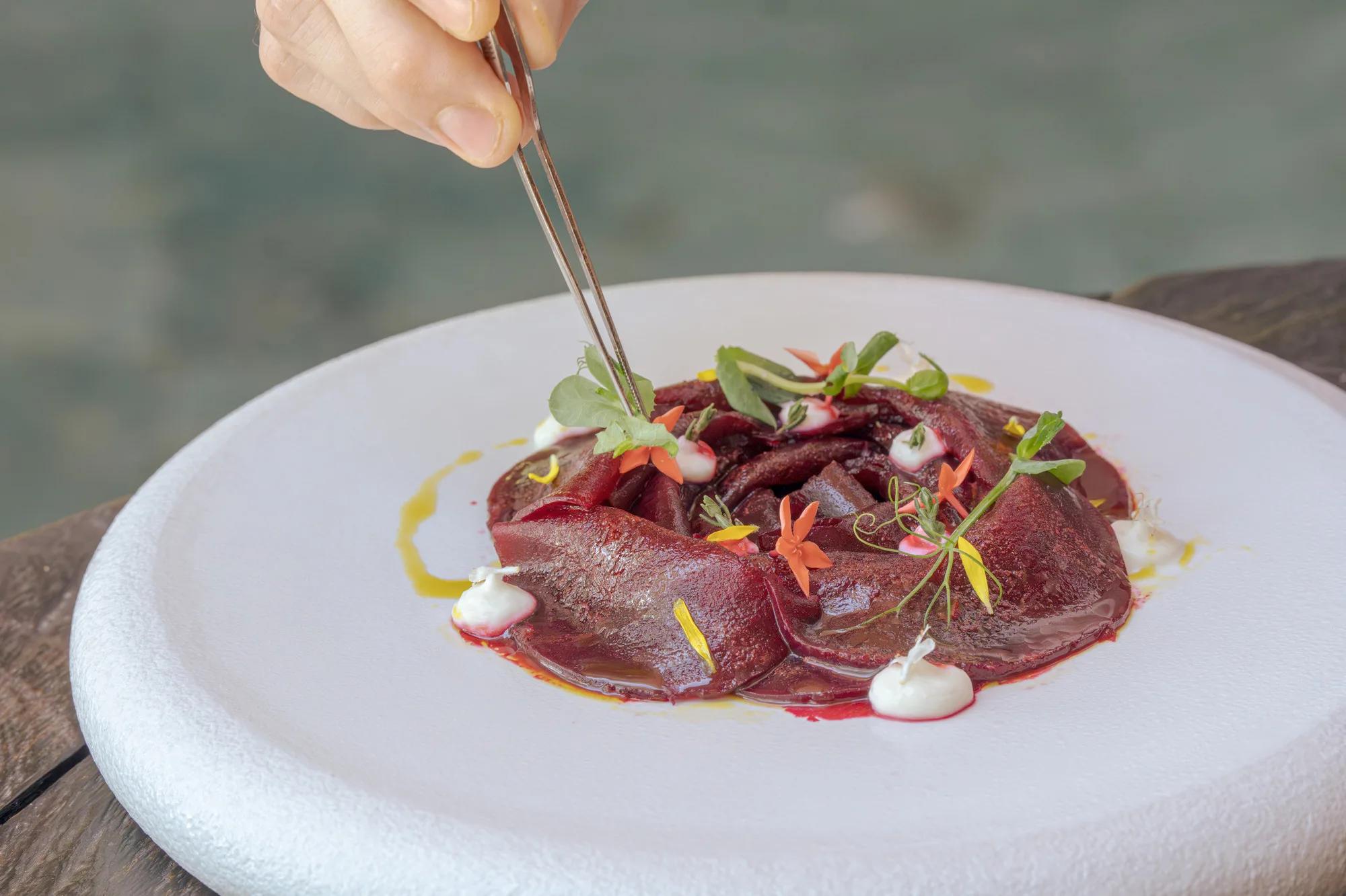 A beet carpaccio plated with edible flowers and micro herbs at Bellinis, JOALI's Italian restaurant