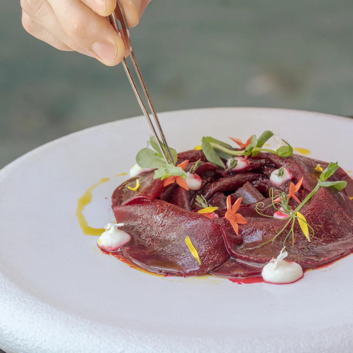 A beet carpaccio plated with edible flowers and micro herbs at Bellinis, JOALI's Italian restaurant