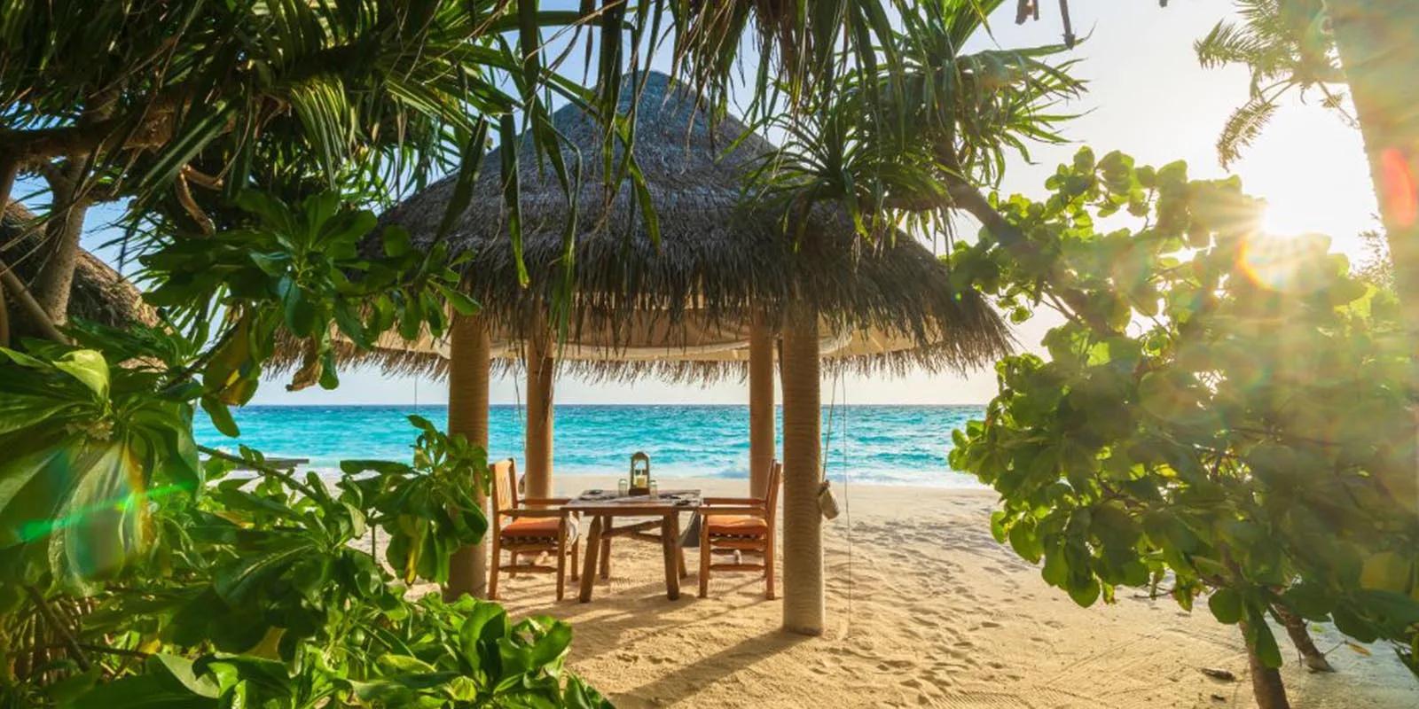 Shoreline Grill's beachfront pavilion at Milaidhoo, set for dinner.