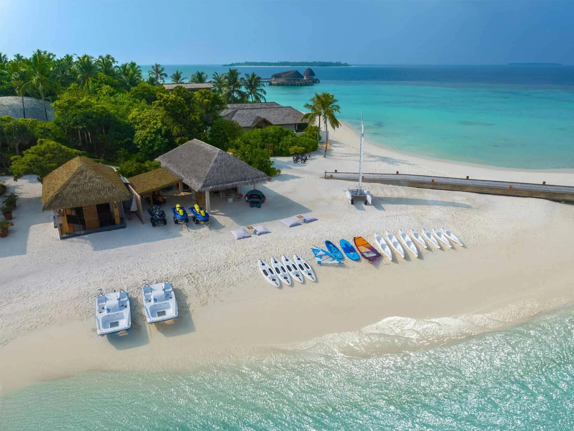 Kayaks and watersports equipment lined up at the Water Sports Center on Emerald Faarufushi's main beach