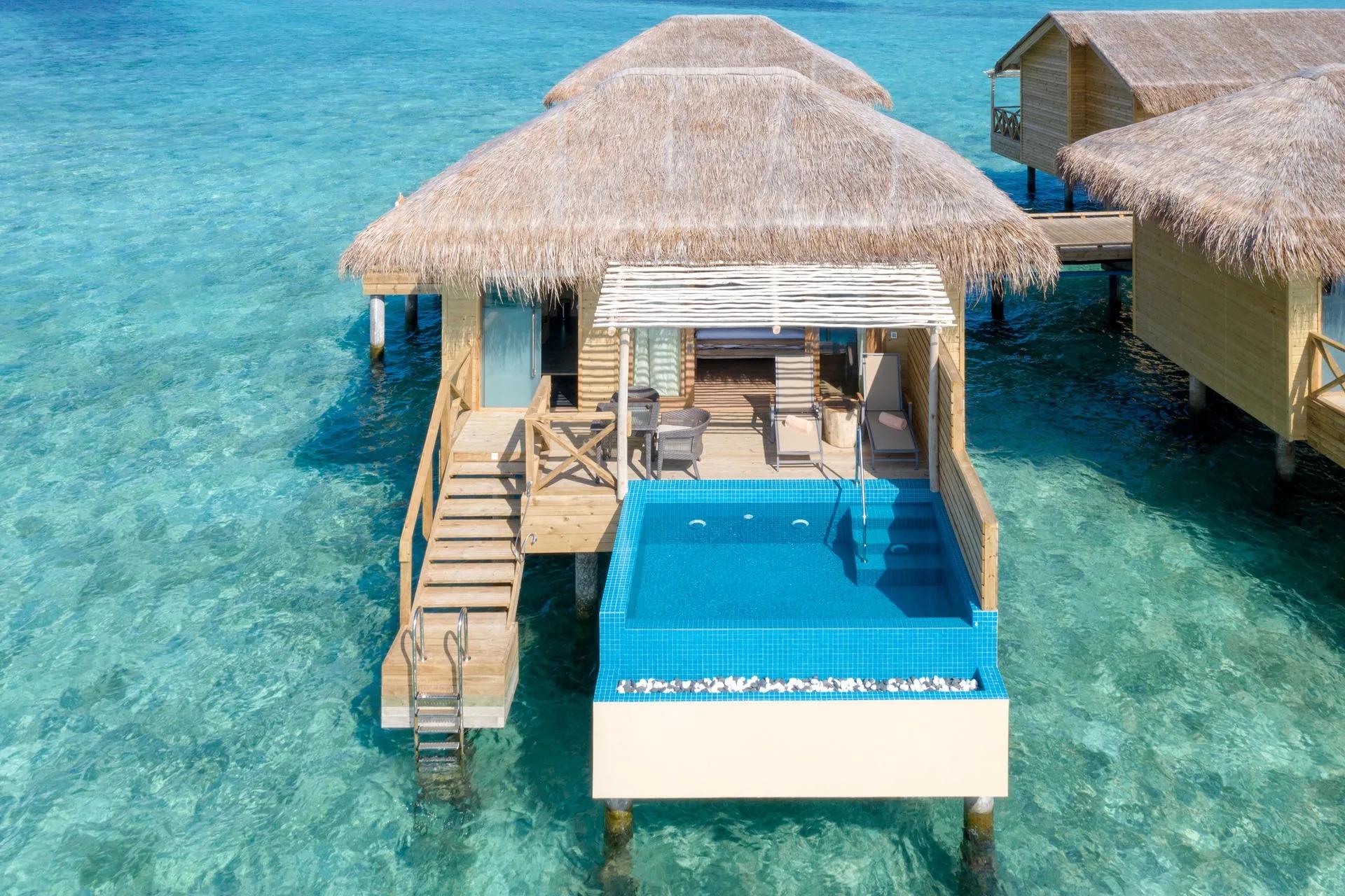 Aerial view of You & Me Maldives, an adults-only private island in Raa Atoll, showing its overwater villa rows