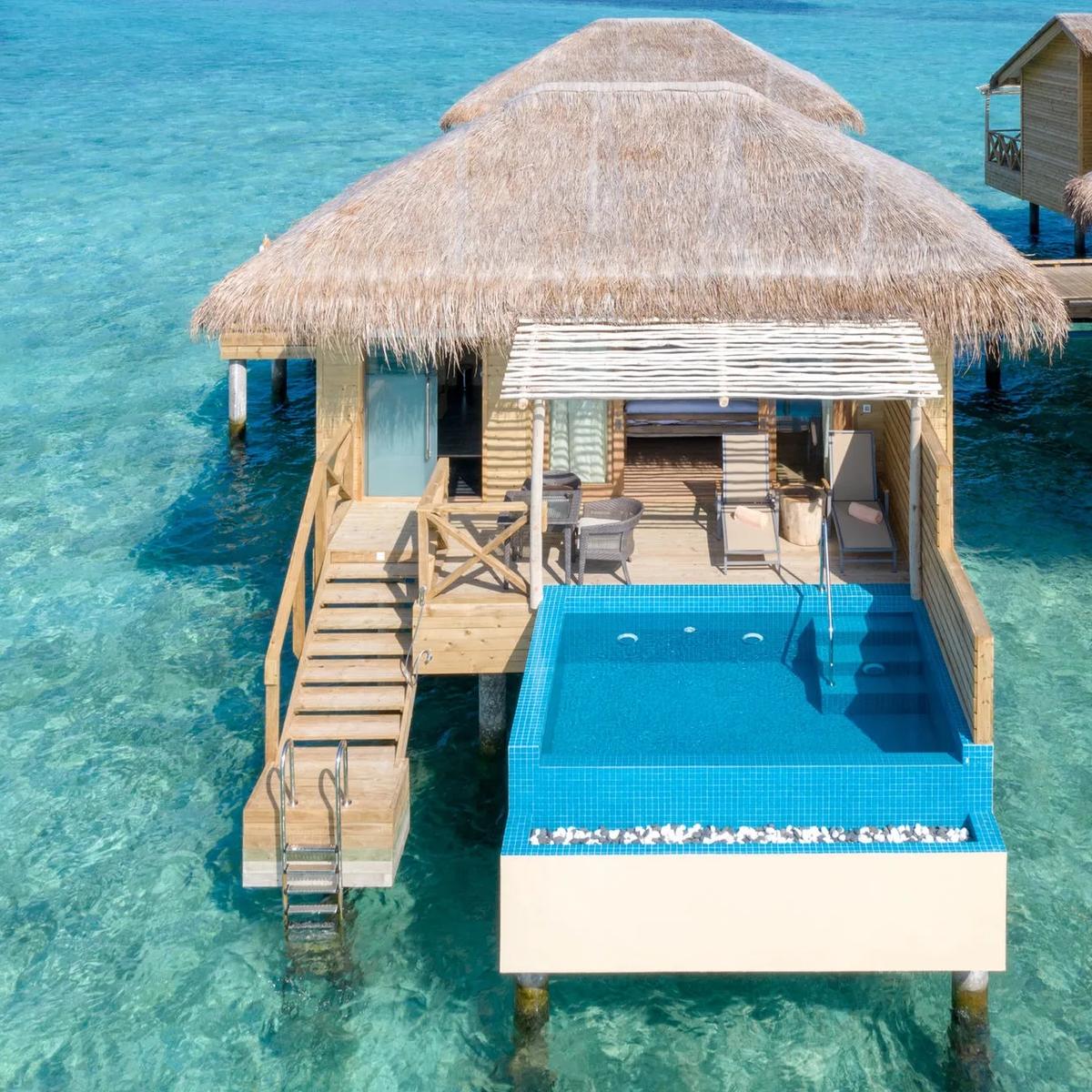 Aerial view of You & Me Maldives, an adults-only private island in Raa Atoll, showing its overwater villa rows