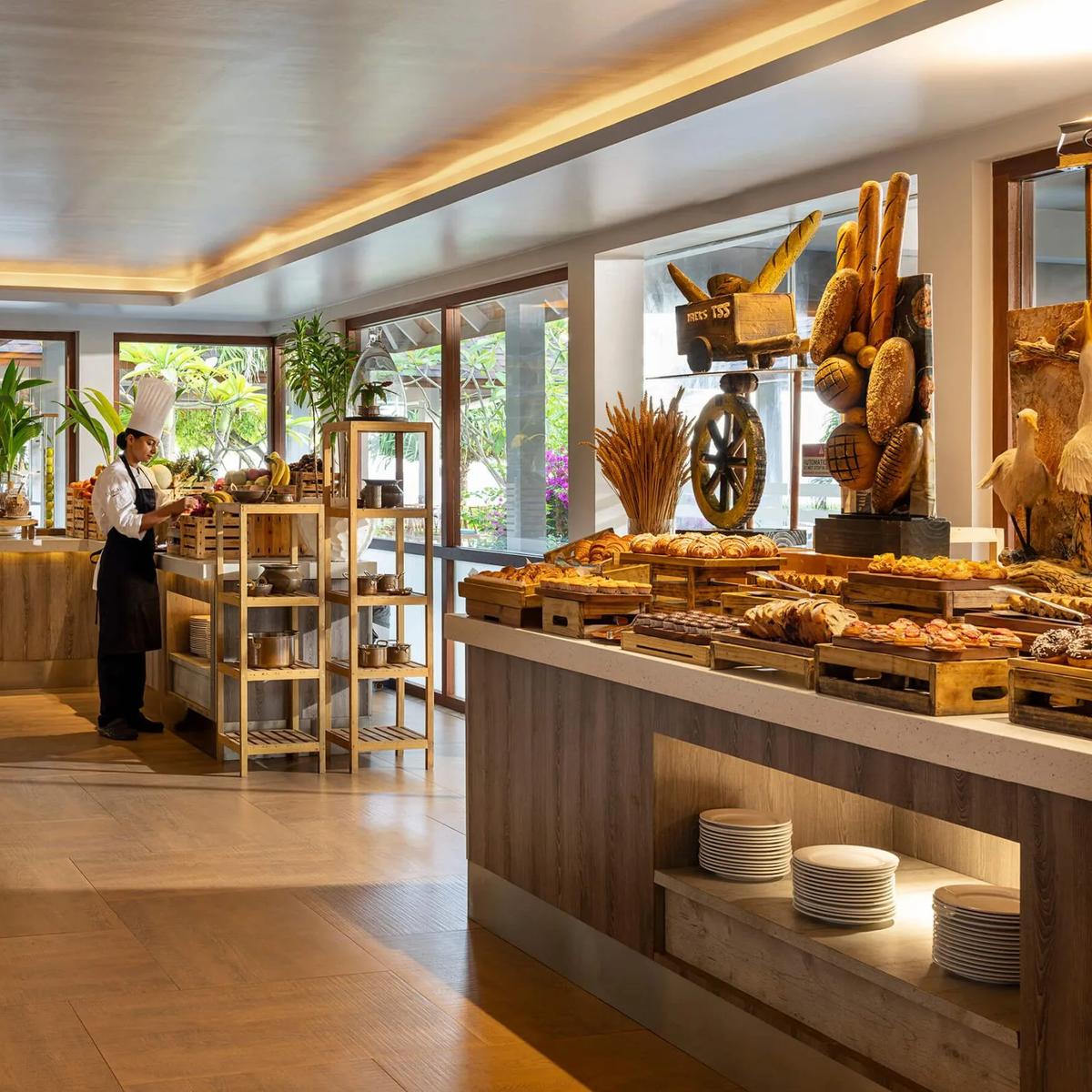 The breakfast buffet spread at Capers, with a chef arranging fresh fruit at the counter